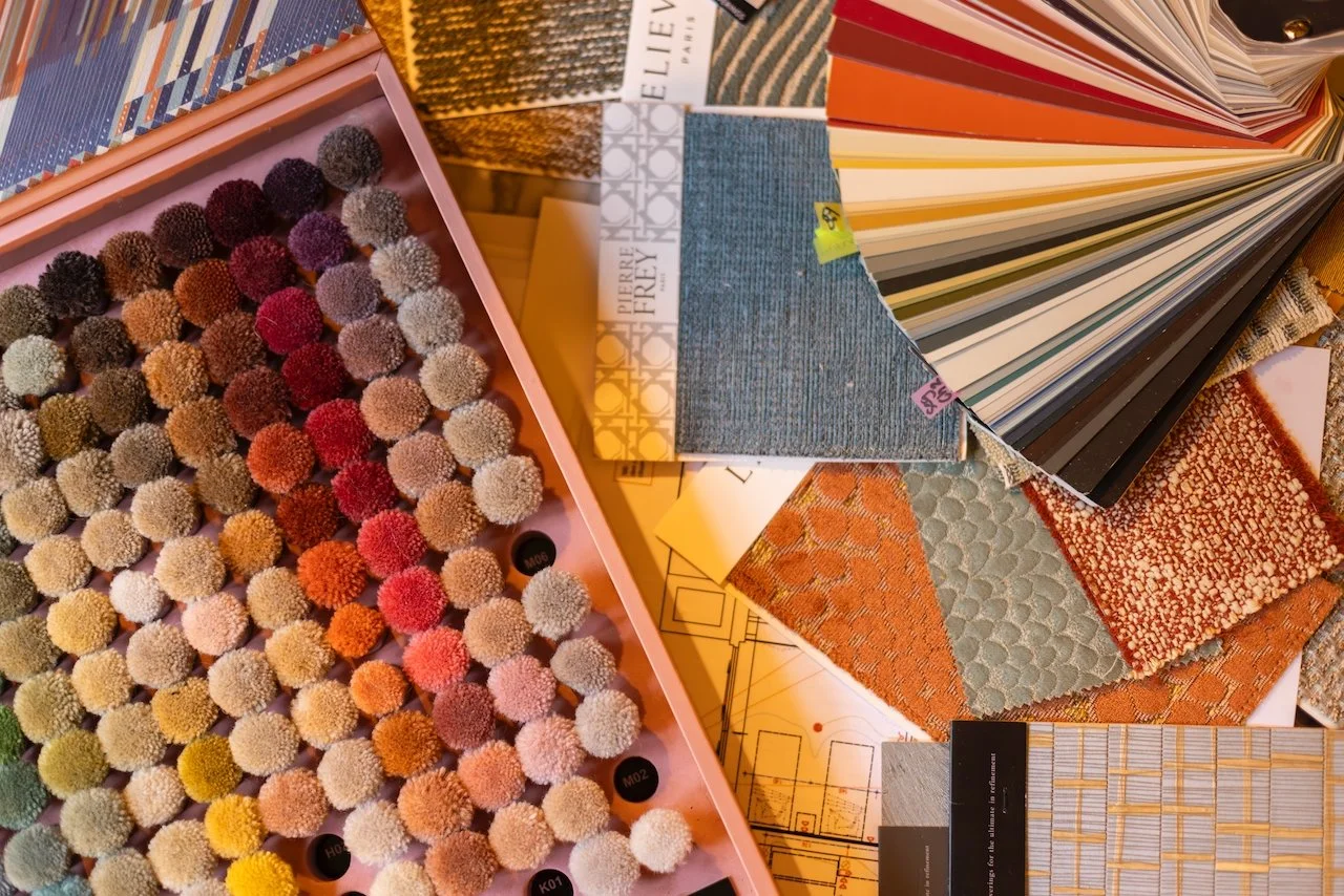 Yasmine B Design turnkey interior decoration services in Paris illustrated by fabric swatches and rug textile pompoms
