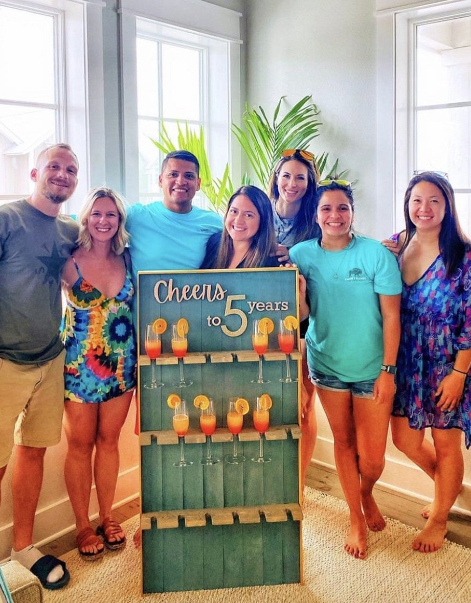 group of people in front of a champagne wall
