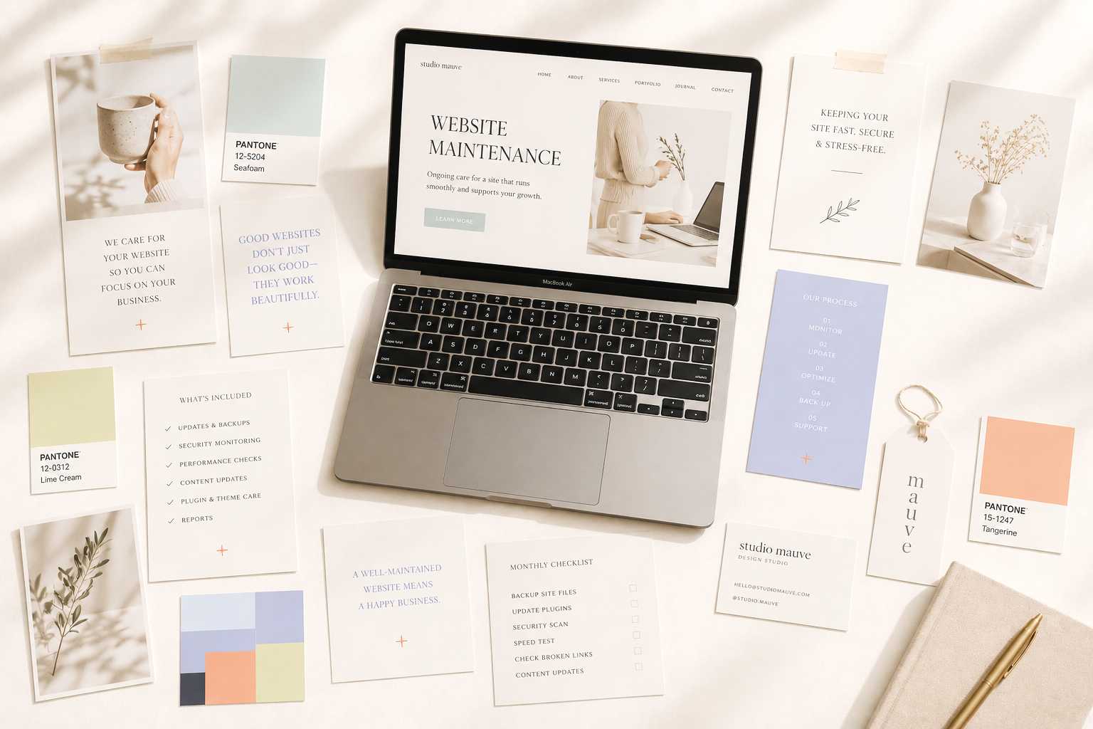 An open laptop on a desk displaying a website titled 'Website Maintenance' with various design and planning materials surrounding it, including color swatches, printed notes, and a pen.