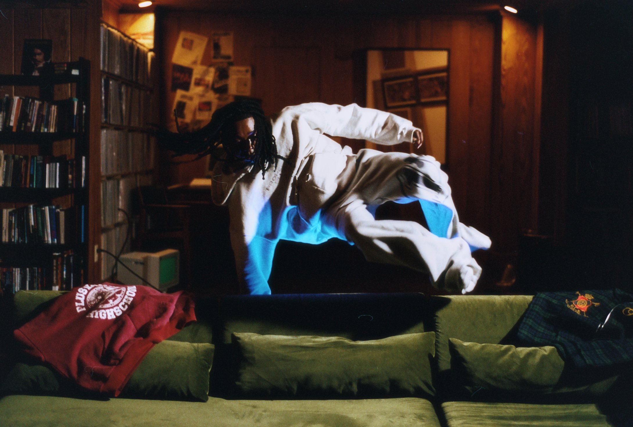 A figure jumping over a green couch