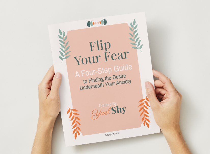 Person holding a book titled 'Flip Your Fear' with a subtitle about a four-step guide to uncovering anxiety, authored by Yael Shy.