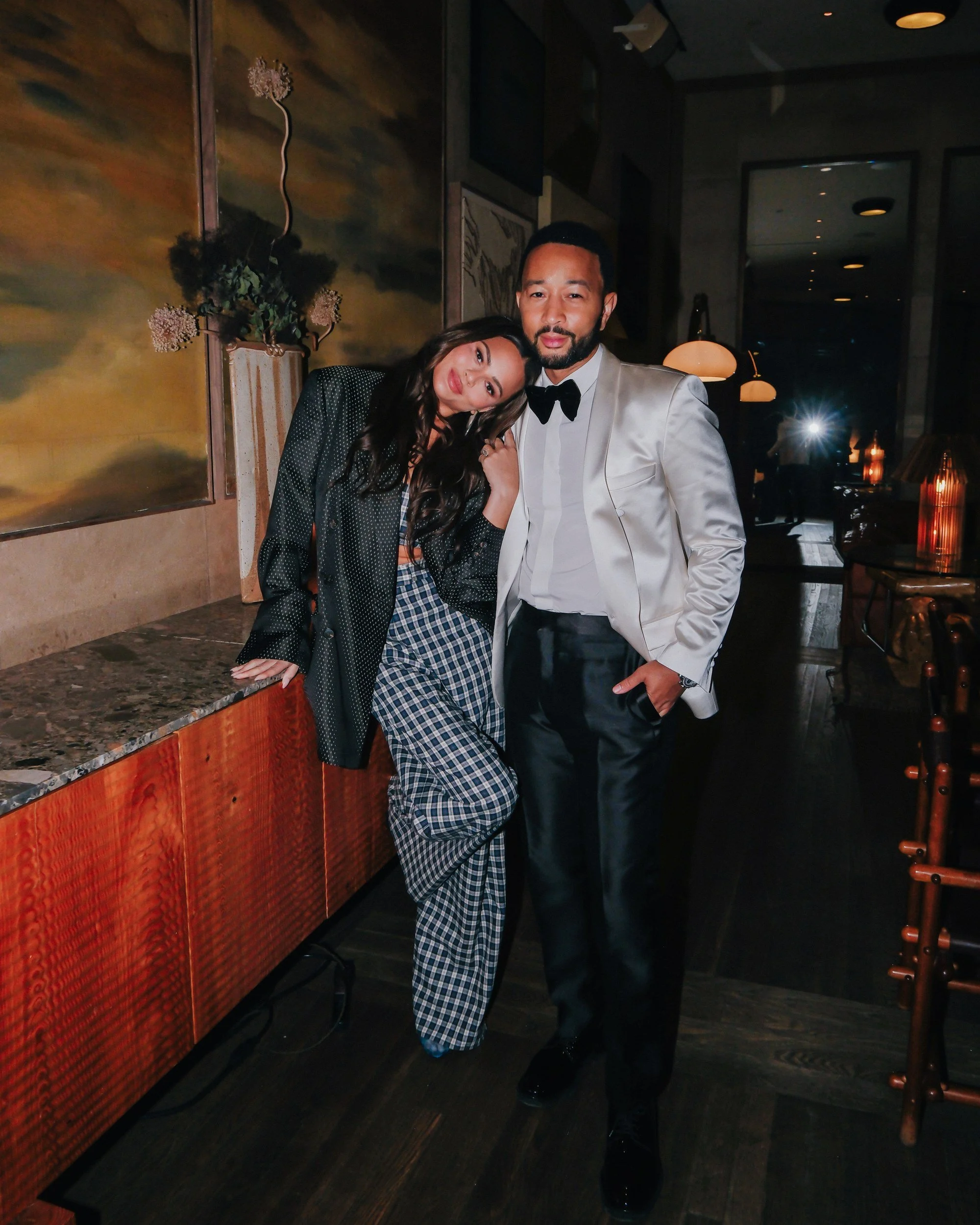 John Legend with a guest at a console in the Santa Monica Proper lobby