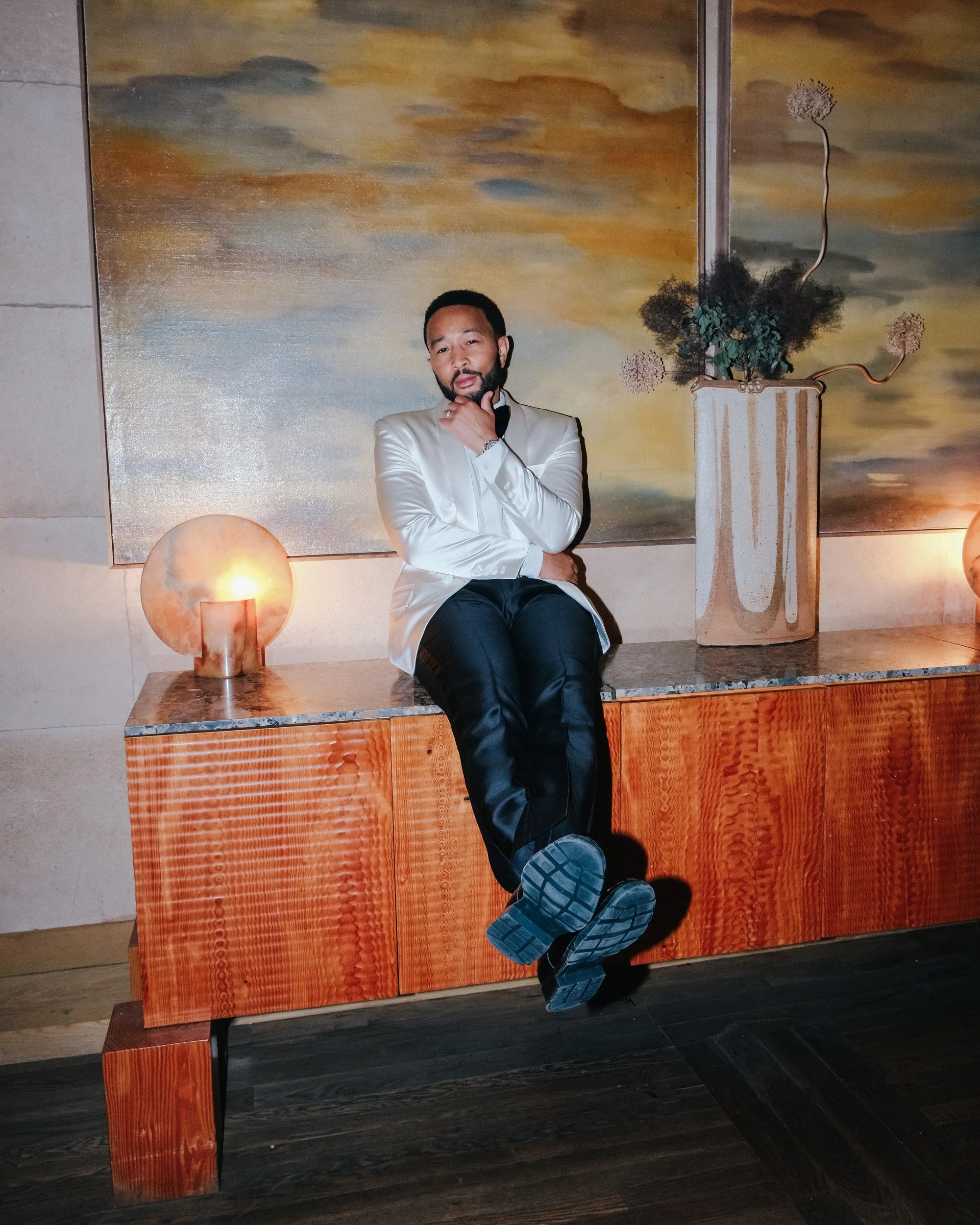 John Legend seated on a console at the Santa Monica Proper Hotel