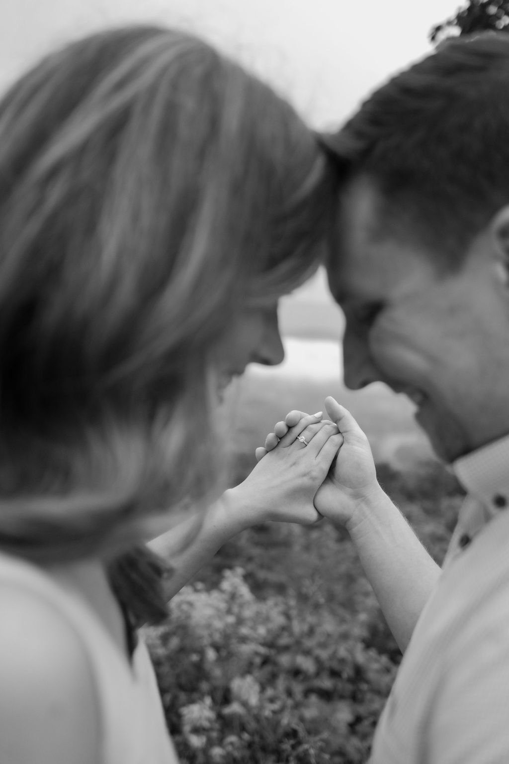 Gatlinburg photographer captures black and white portrait of man and woman forehead's touching with engagement ring as center