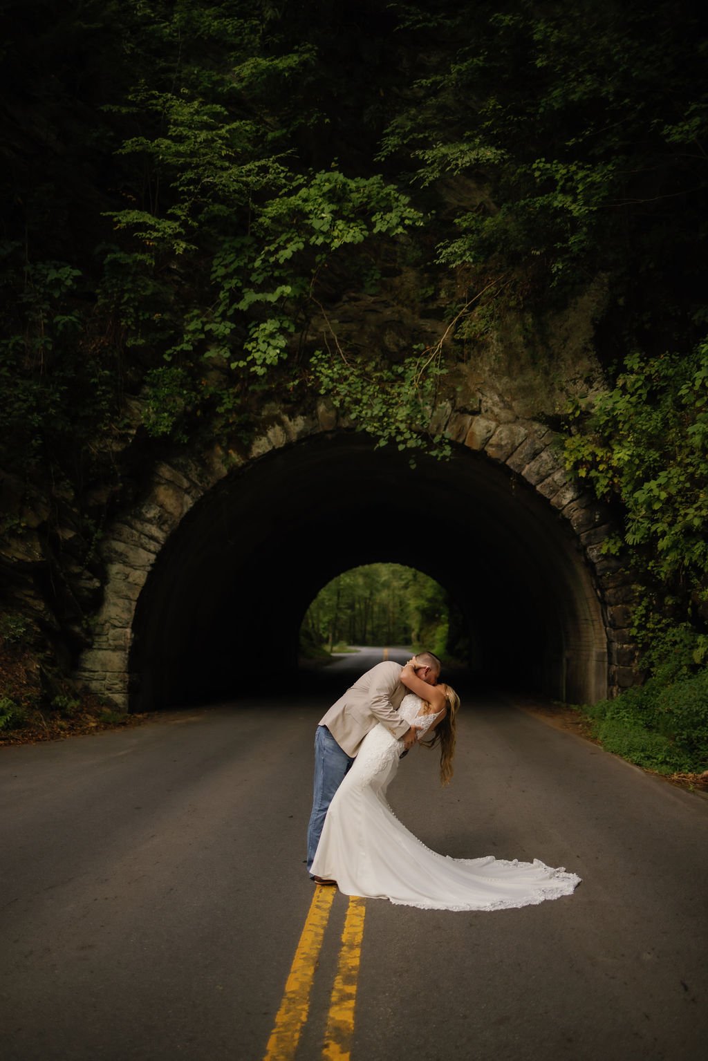 gatlinburg-wedding-photographer-if-uncles-brings-a-camera-to-a-gatlinburg-wedding-couple-kissing-in-front-of-tunnel