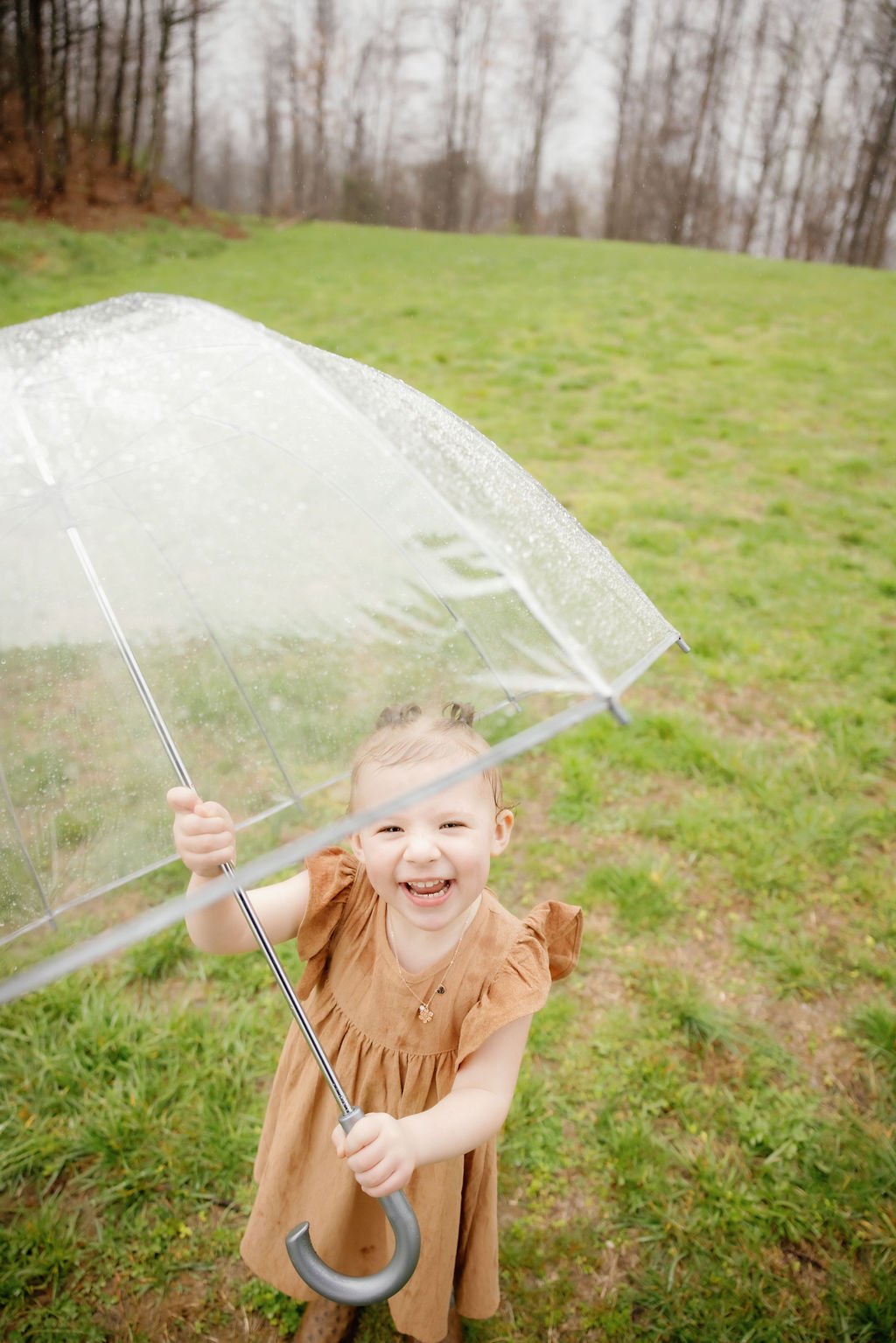 gatlinburg-family-photographer-tips-for-family-photos-with-a-toddler-toddler-playing-with-clear-umbrella