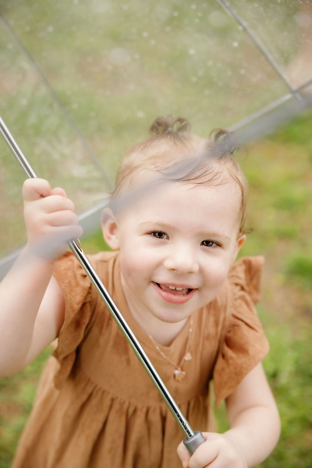 gatlinburg-family-photographer-tips-for-family-photos-with-a-toddler-child-holding-umbrella-smiling