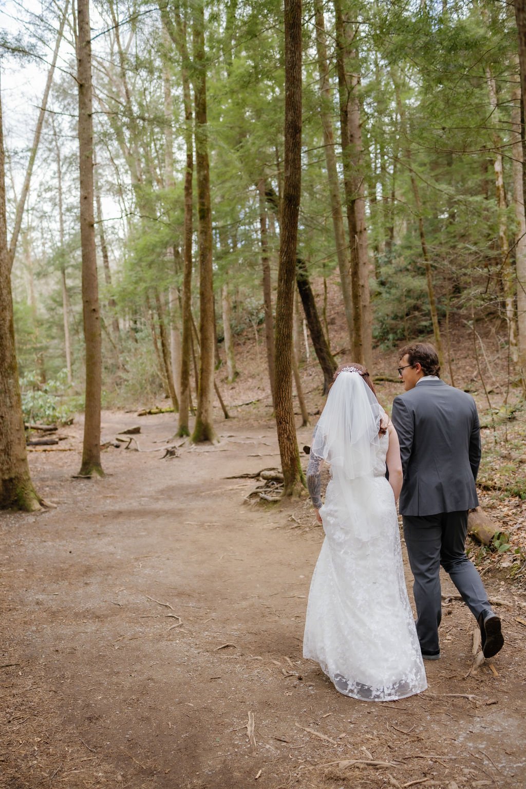 gatlinburg-photographer-waterfall-elopement-in-the-smoky-mountains-couple-walking-through-forest