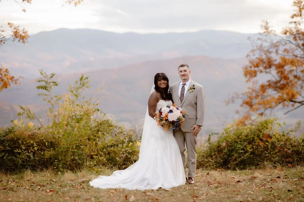Bride and groom posing with bouquet at scenic mountain overlook, foothills parkway elopement photography capturing intimate Smoky Mountains fall wedding portrait with panoramic views by a gatlinburg photographer specializing in outdoor elopements