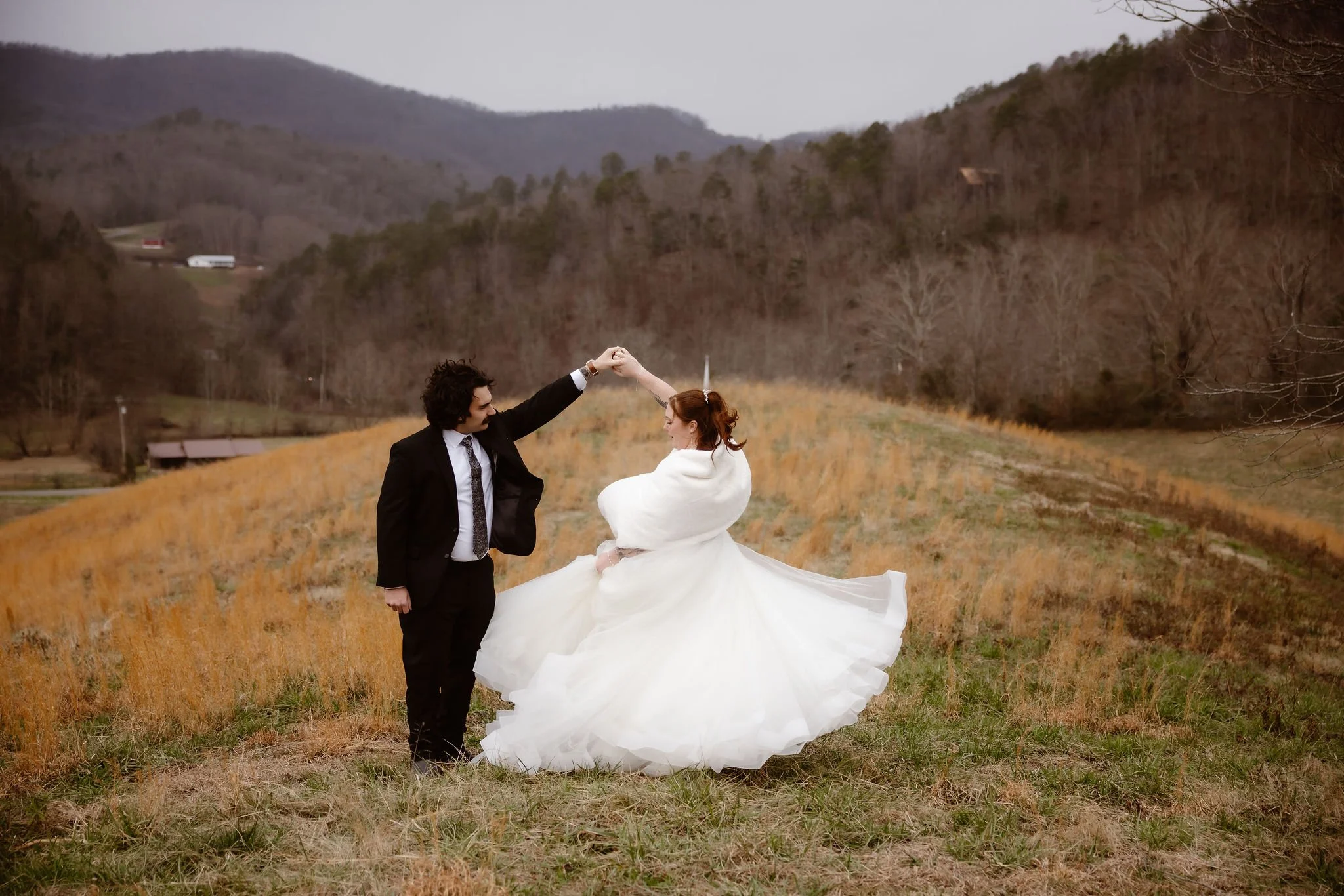 Bride and groom dancing together in an open mountain field after their Smoky Mountain micro wedding ceremony, photographed by a Gatlinburg elopement photographer.