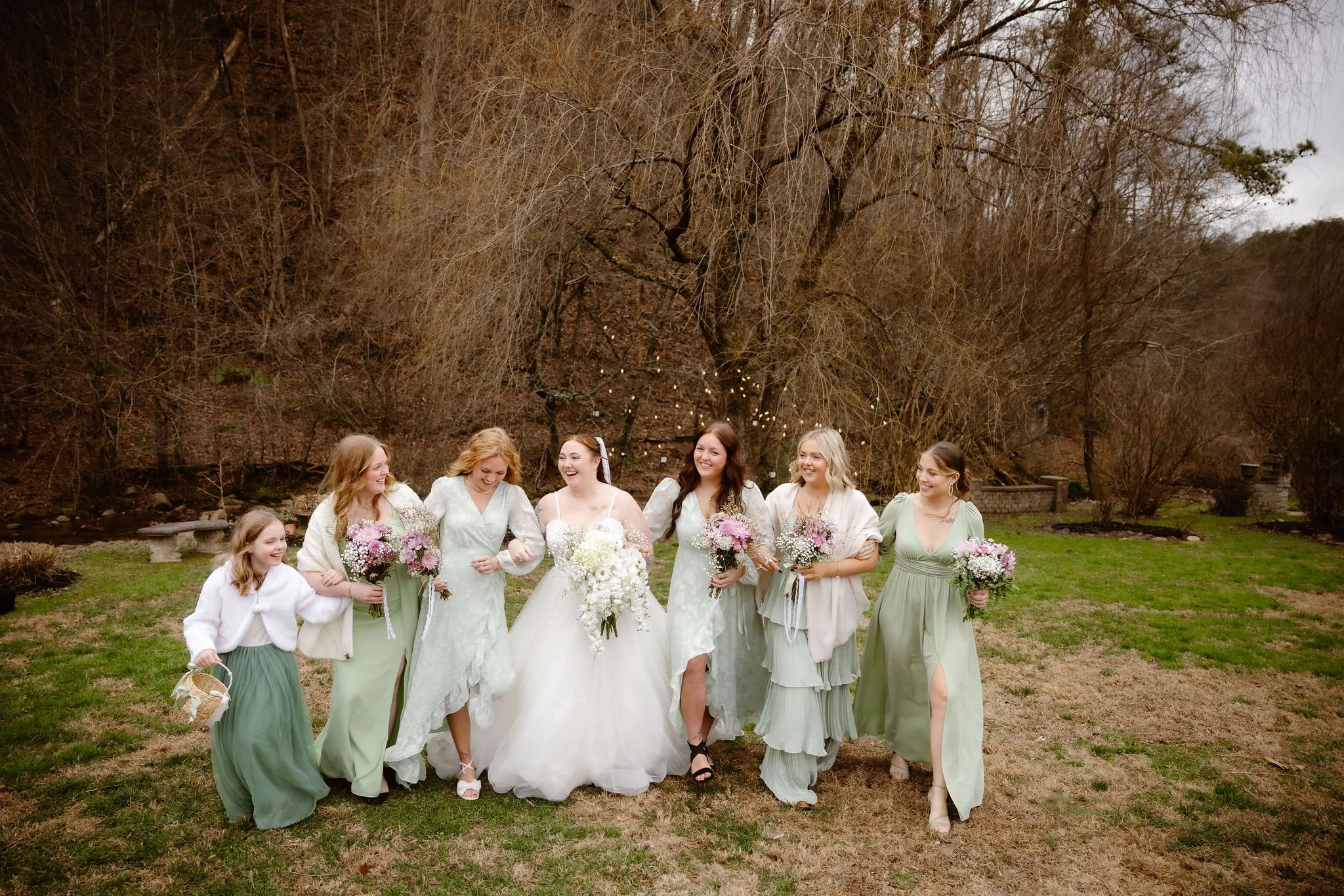 Bride and bridesmaids walking together outdoors with bouquets after a joyful micro wedding ceremony, captured by a Gatlinburg elopement photographer.