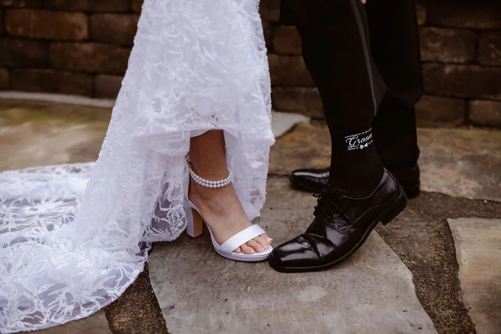 Close-up of the bride’s wedding heels and groom’s dress shoes during their ceremony at Gatlinburg wedding cabins, photographed by an elopement photographer highlighting meaningful wedding details.