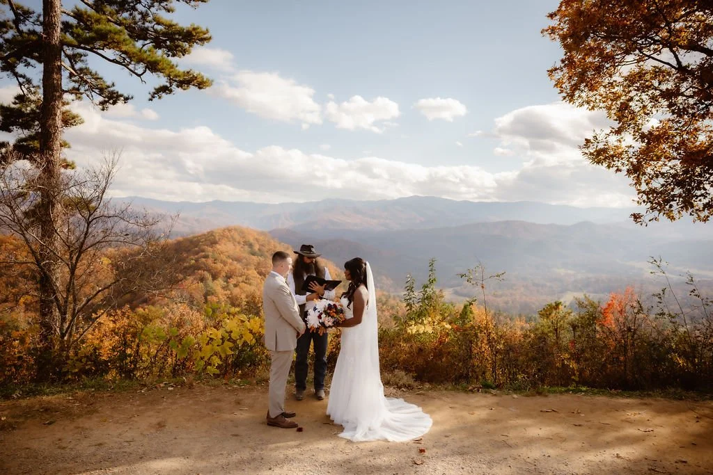 Outdoor wedding ceremony at scenic mountain overlook with officiant and couple exchanging vows, foothills parkway elopement photography capturing intimate Smoky Mountains fall wedding