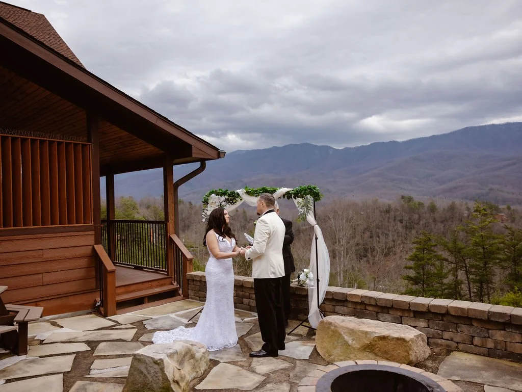 Couple exchanges vows during an intimate outdoor ceremony at one of the scenic Gatlinburg wedding cabins, with mountain views captured by an elopement photographer.