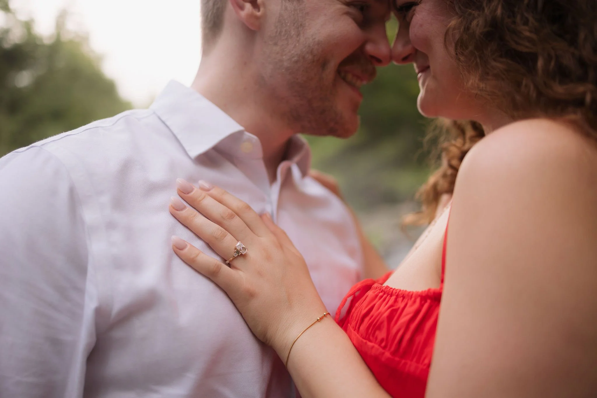 Close-up of an engagement ring as the couple stands forehead to forehead following their surprise proposal.