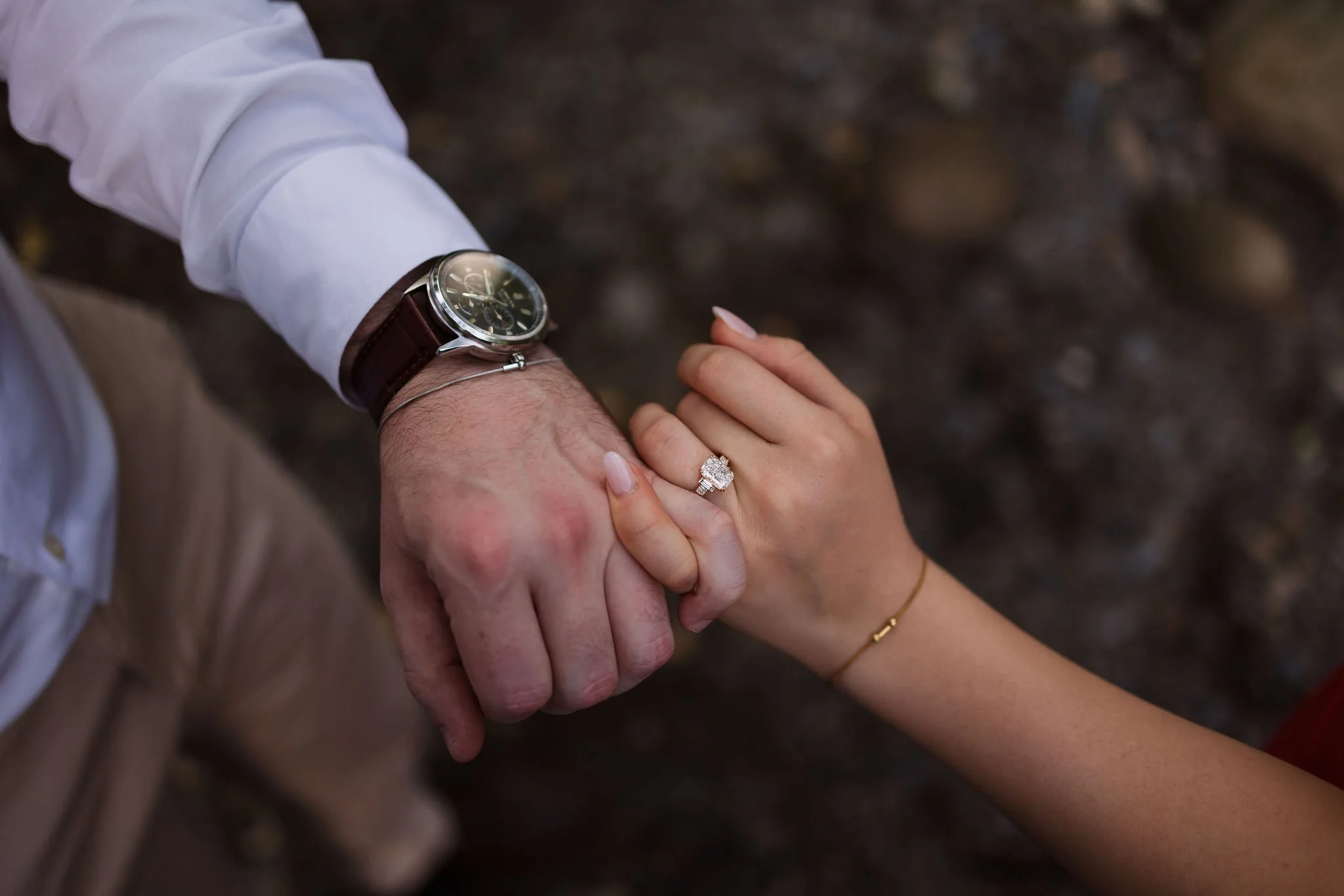 Close-up of the couple holding hands, highlighting the diamond engagement ring from their gatlinburg proposal.