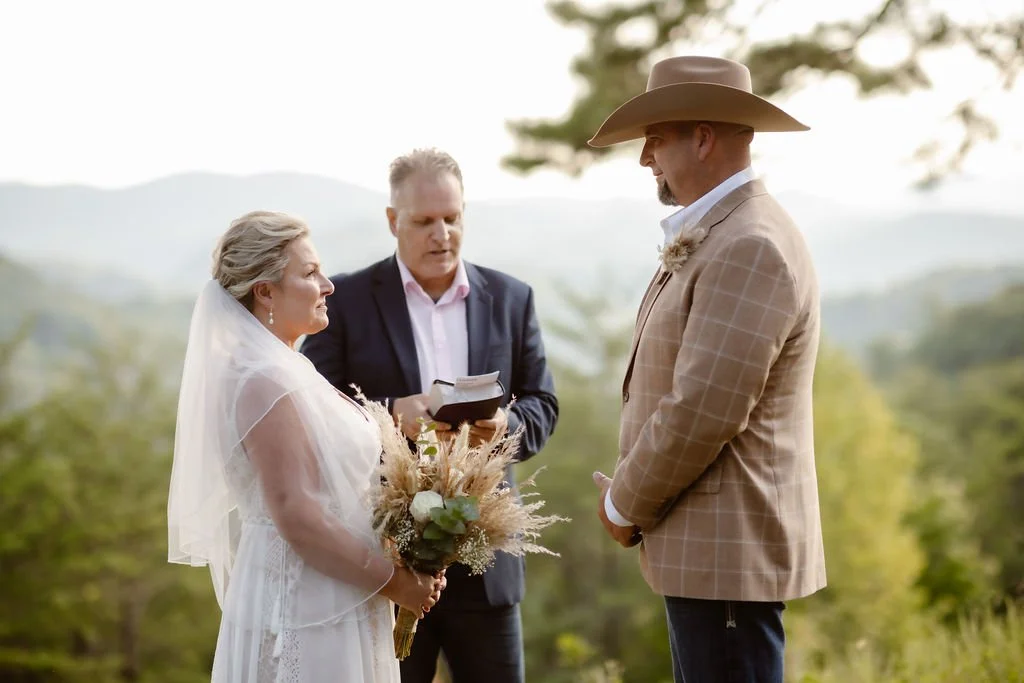 Sunset elopement ceremony at Foothills Parkway in the Smoky Mountains, with the bride and groom exchanging vows before an officiant during their intimate Smoky Mountain elopement overlooking scenic mountain views.