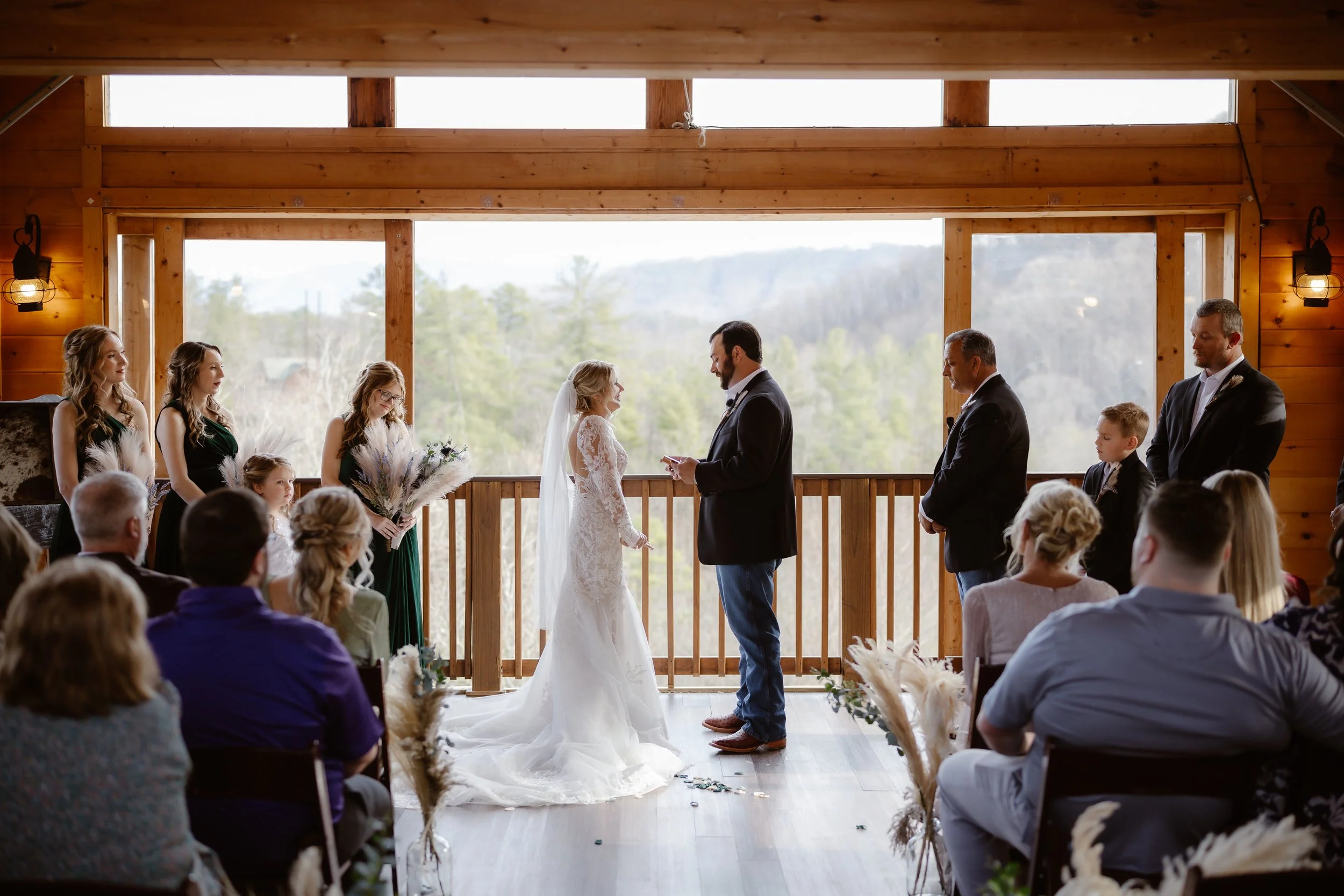 Indoor wedding ceremony at Parkside resort with bride and groom exchanging vows in front of mountain views during a Smoky Mountain elopement, photographed by a Gatlinburg photographer.