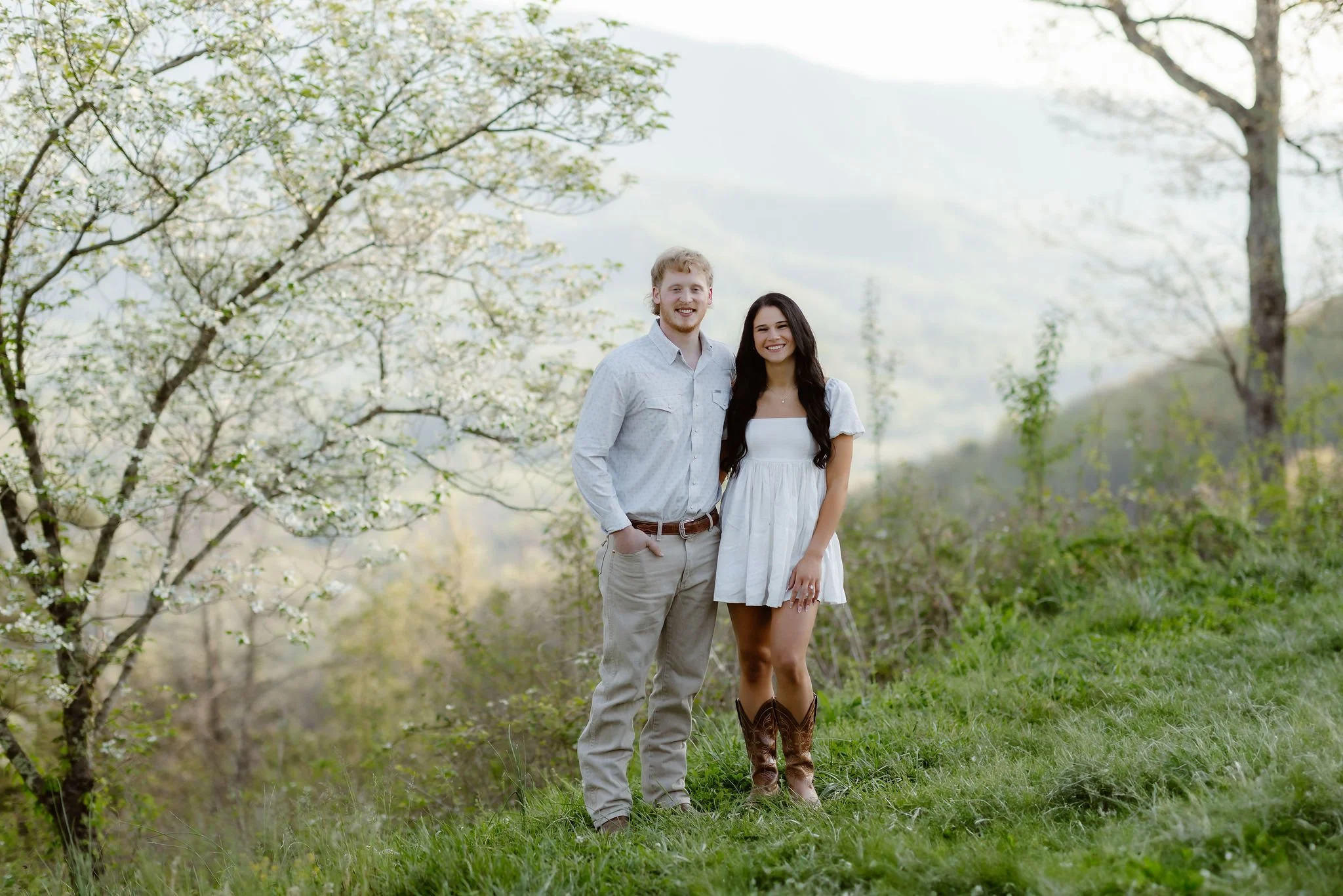 Engaged couple posing together with the Smoky Mountains in the background during a session with a Gatlinburg photographer.