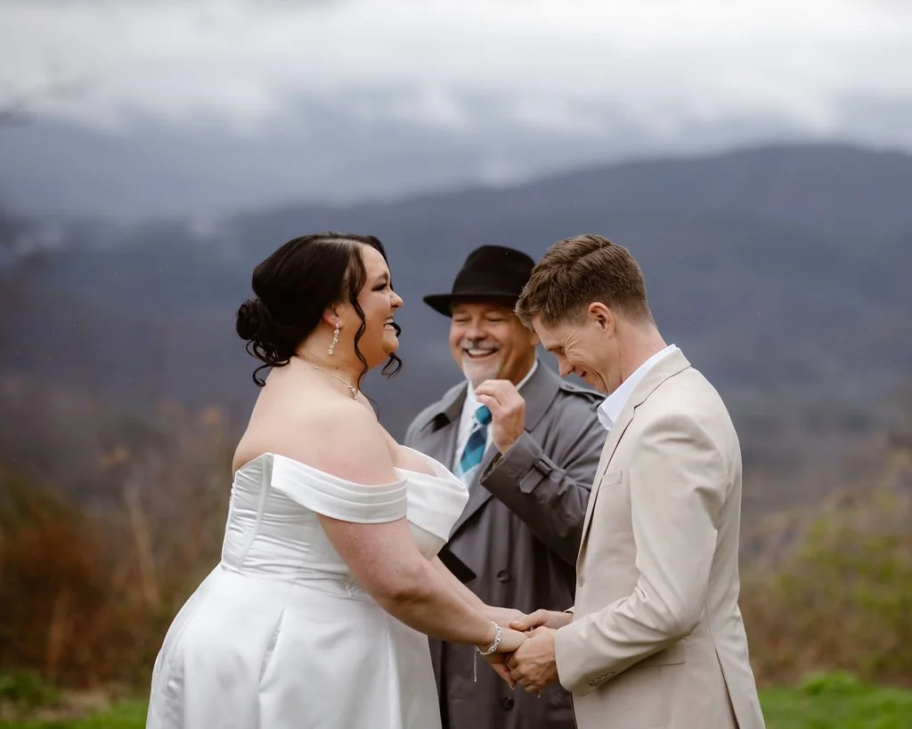 Bride and groom holding hands and smiling during their mountain ceremony with an officiant, captured by a gatlinburg photographer at a foothills elopement
