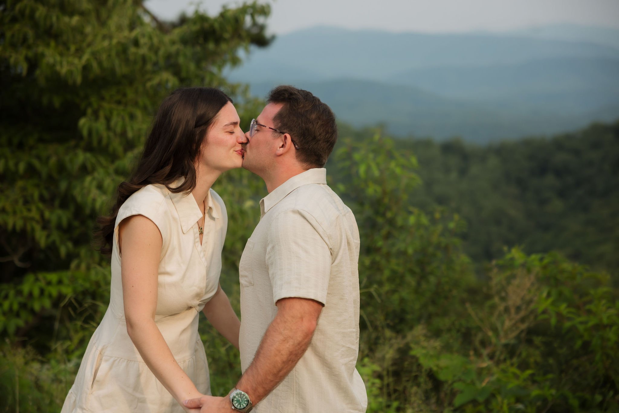 Couple sharing a kiss during their smoky mountain engagement with scenic mountain views in the background, photographed by a Gatlinburg photographer.