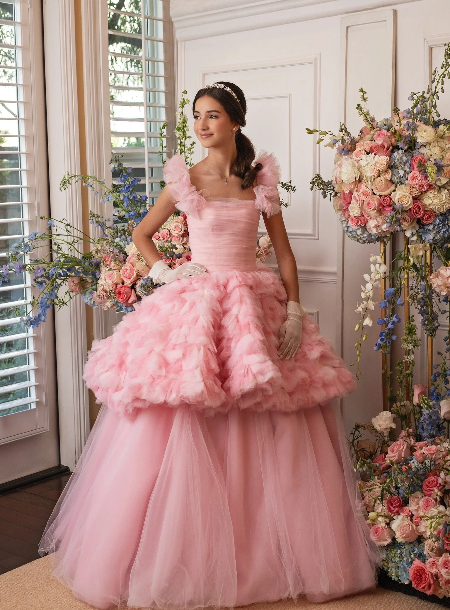 A modern couture quinceañera gown by RMINÉ, designed in layered pink and ivory tulle with a dramatic runway-worthy silhouette.