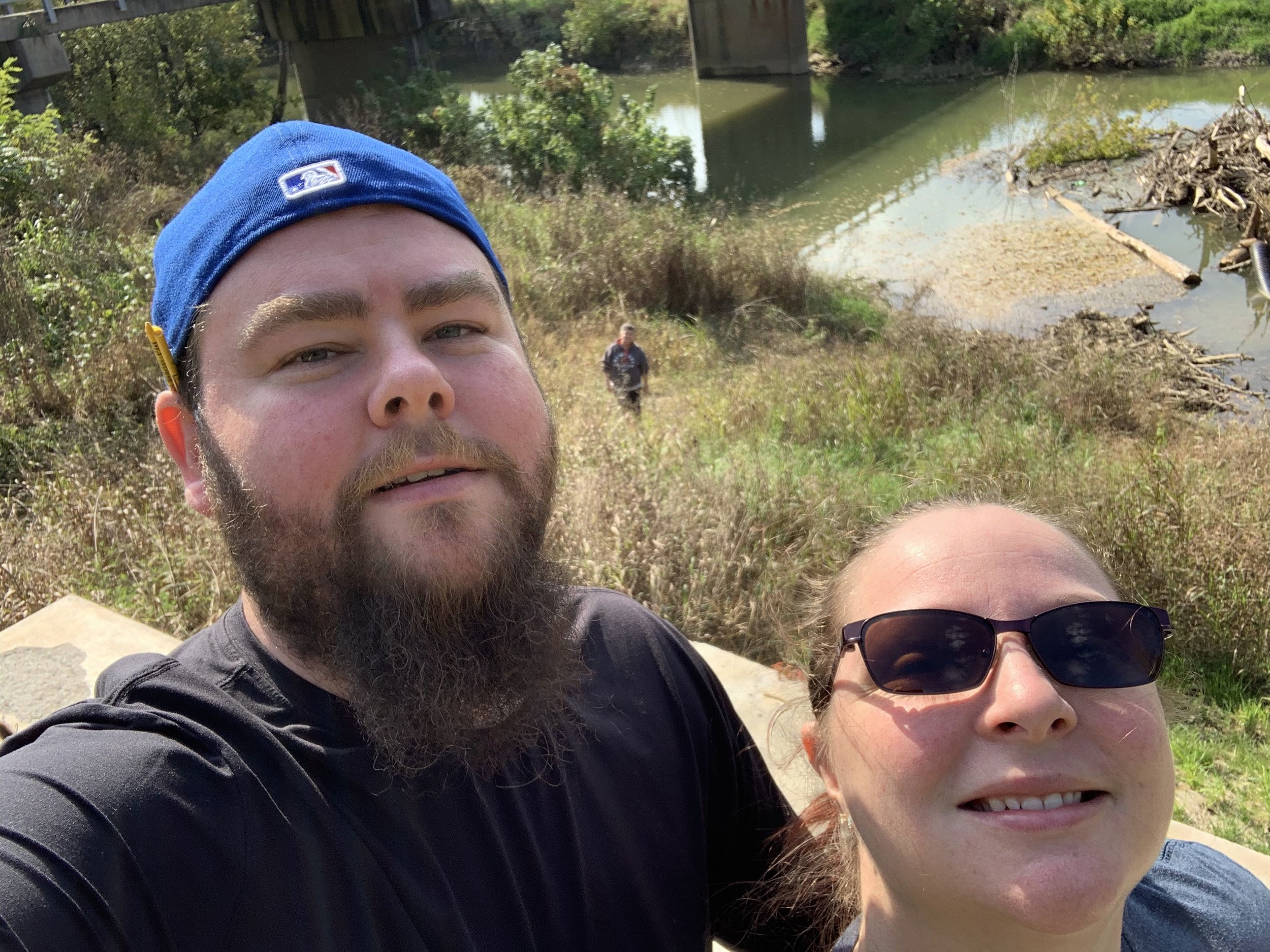 The Wife and I Standing on One Side of the Creek, Mom in the Background