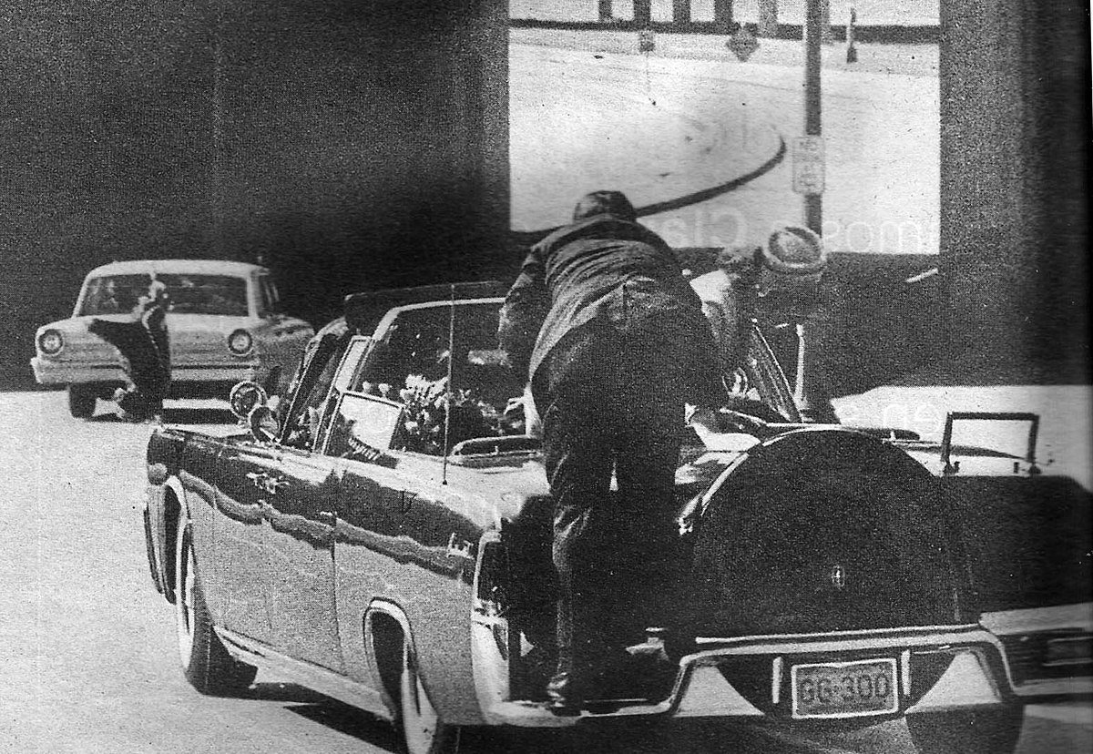  Clint Hill Climbing Onto the Running Board of the Car 