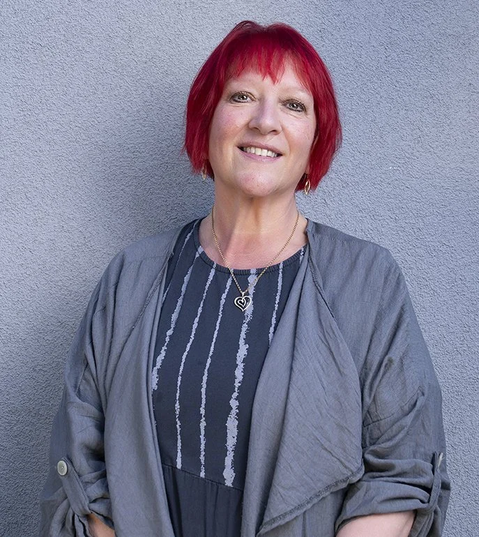 A portrait photo of a smiling woman with red hair
