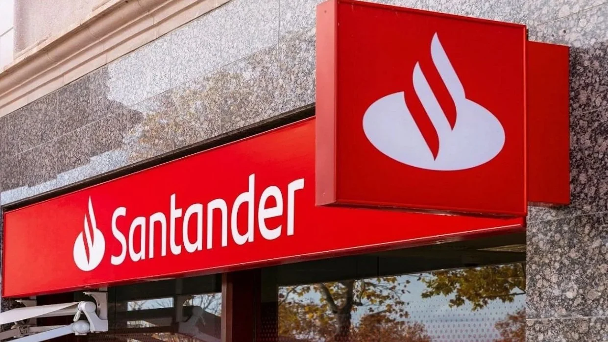 Exterior of a Santander bank branch with a bright red sign featuring the bank's name and logo, which includes a stylized flame symbol.