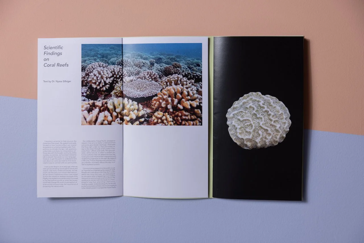 Open magazine featuring coral reefs on the left page and a coral on a black background on the right page.