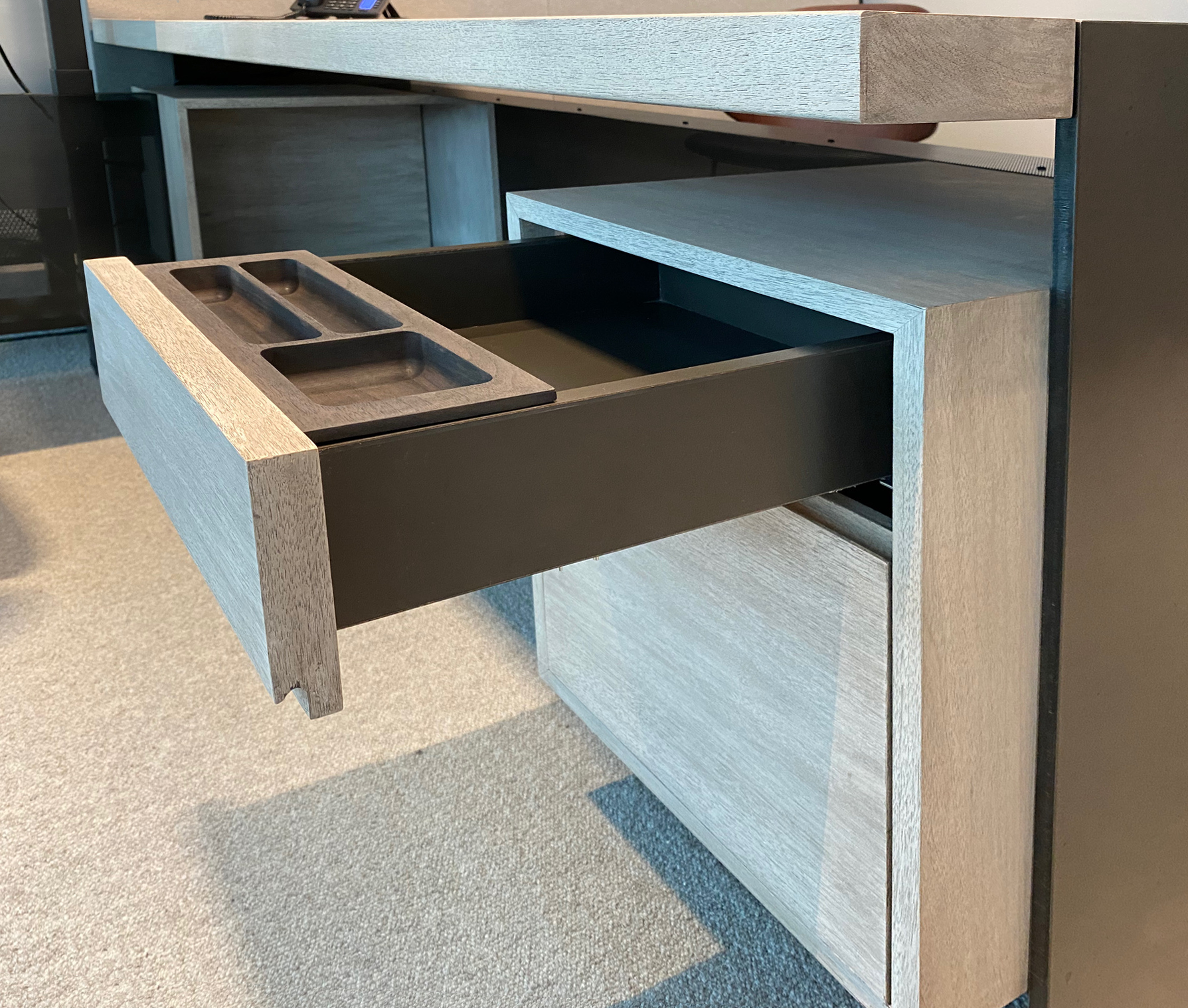 CUSTOM PENCIL TRAYS FIT AND SLIDE IN THE TOP DRAWERS OF FLOATING FILE CABINETS CONCEALED BENEATH DESK SURFACES.