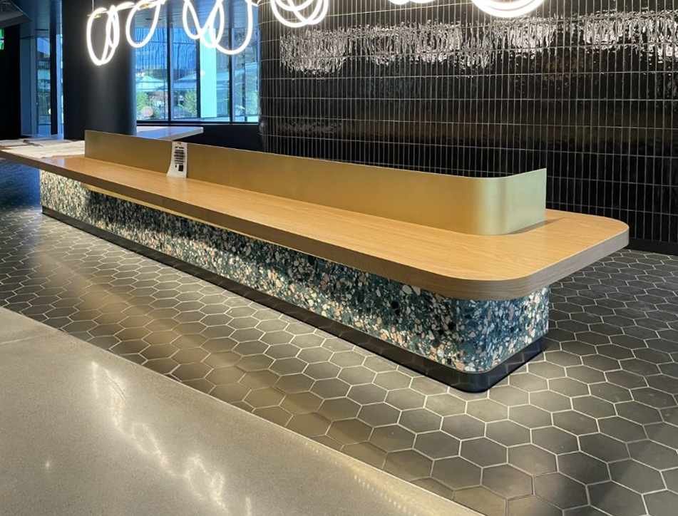 RECEPTION DESK WITH THICK WHITE OAK VENEER TOP AND MATCHING SOLID WOOD EDGE, STONE WRAP, AND METAL SCREEN