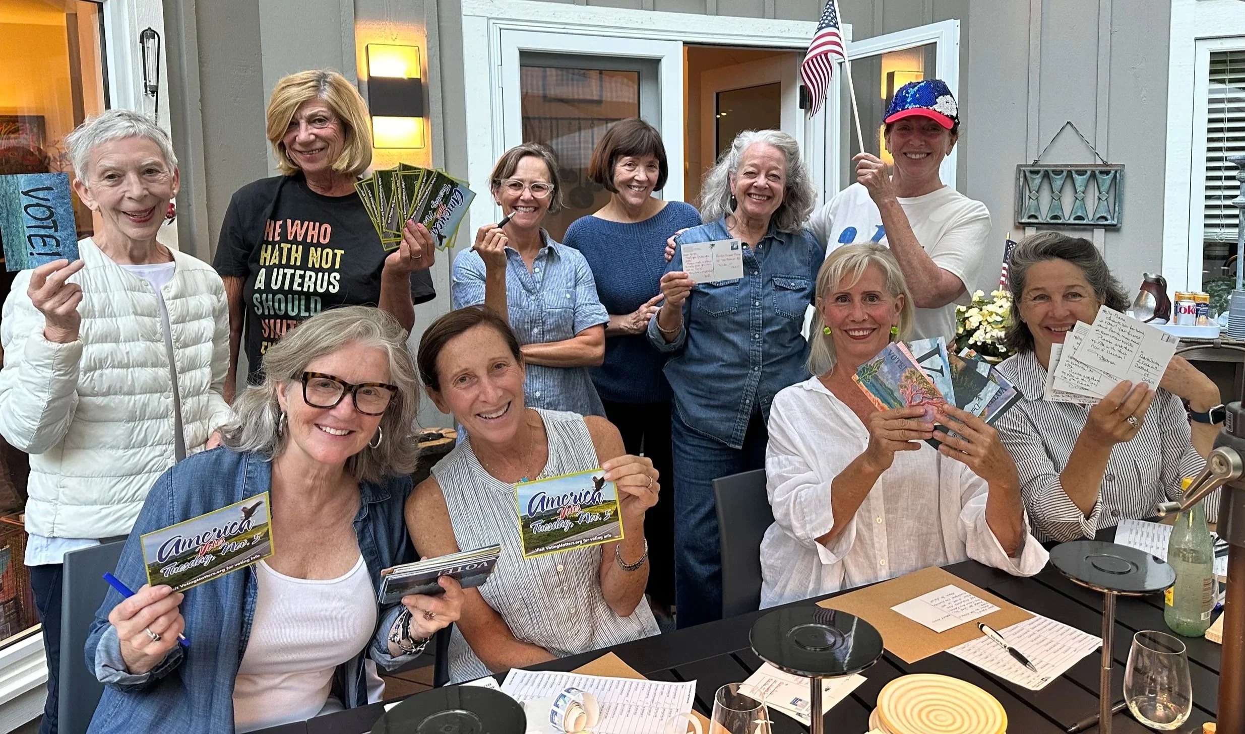 A group of women volunteering with Indivisible Chicago to send postcards to swing state voters.
