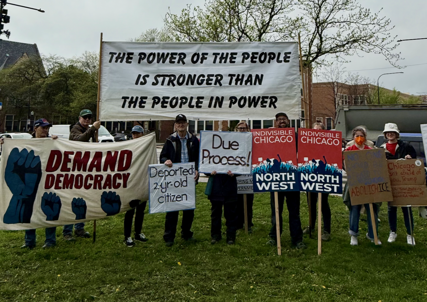 Indivisible Chicago Northwest members hold protest signs at the May Day rally and march in 2025