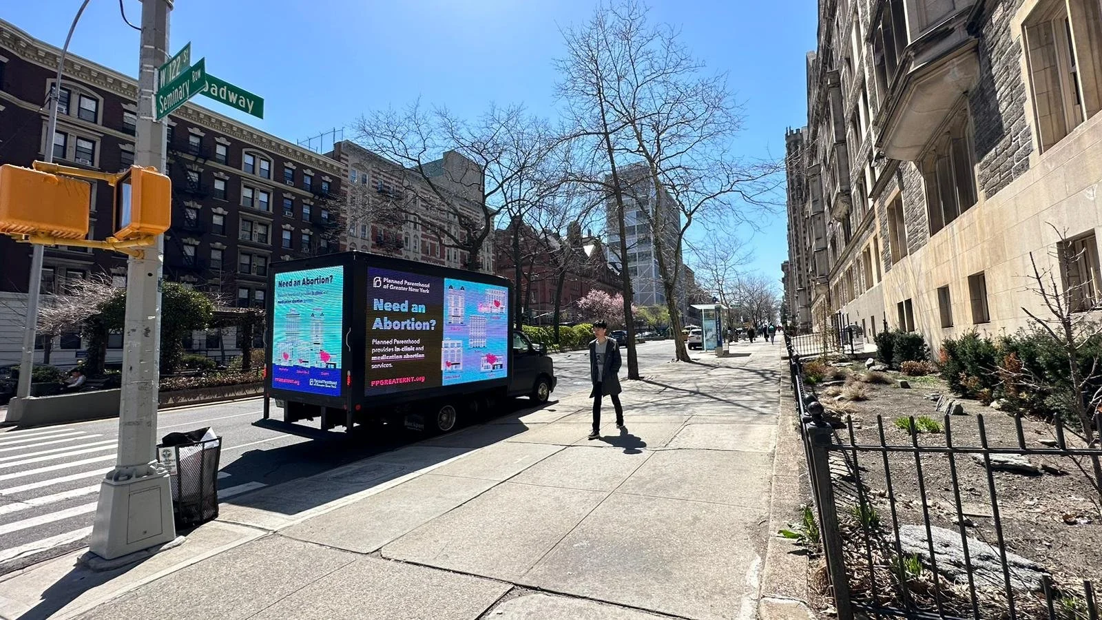 Street view with Planned Parenthood advertising truck and buildings