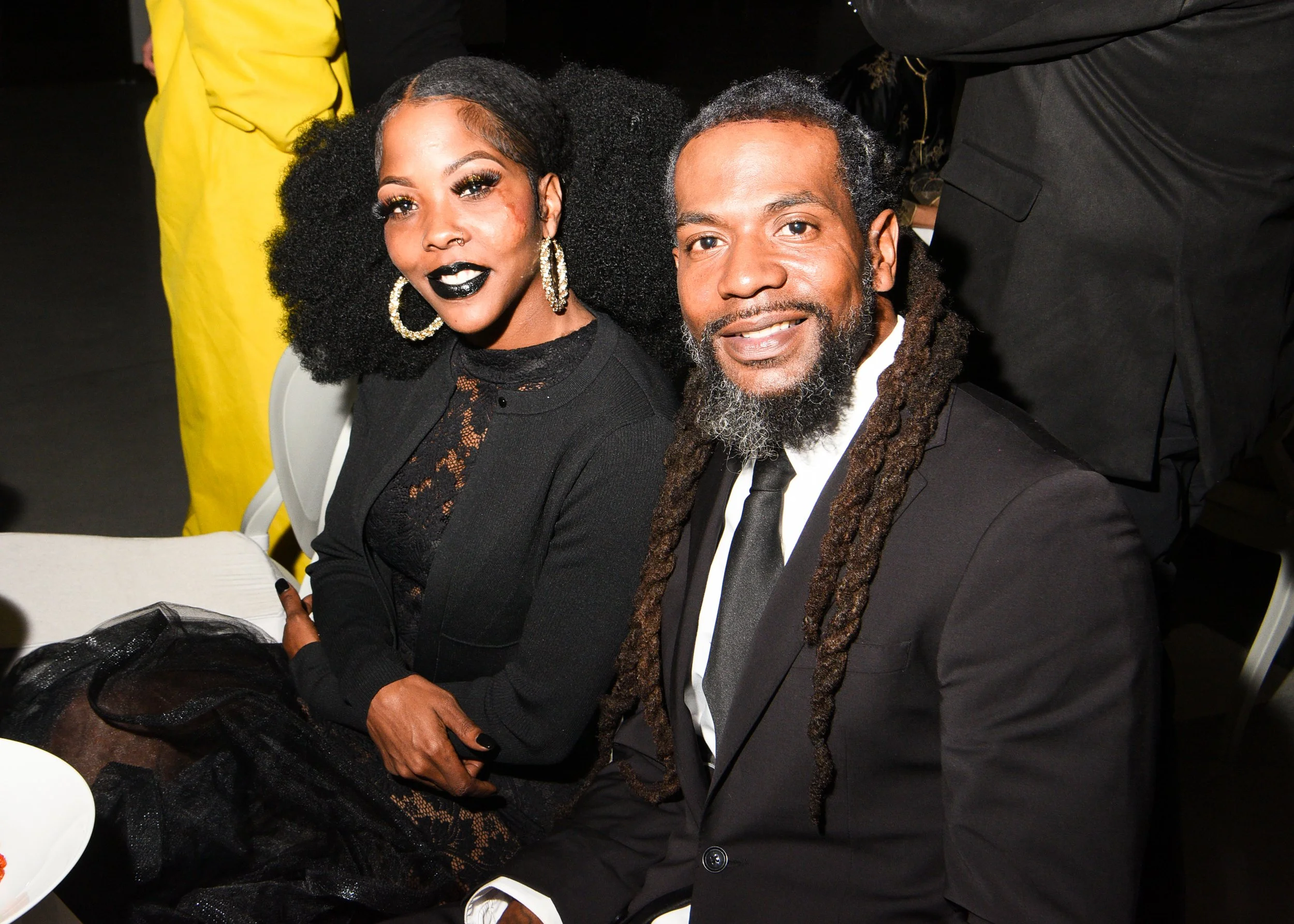 A man and a woman dressed formally, smiling at an event.