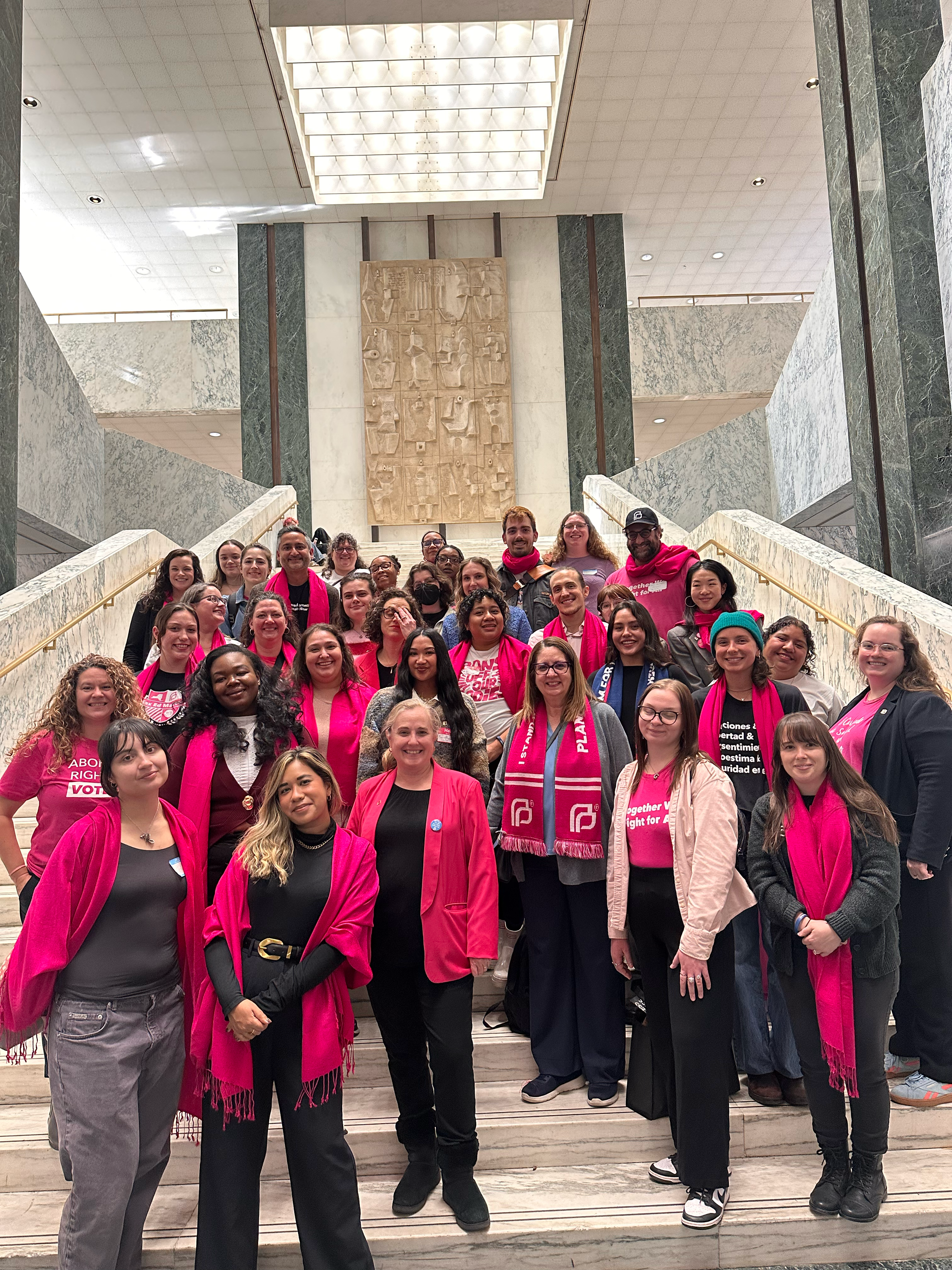 Activists attend Day of Action and pose on stairs together.png