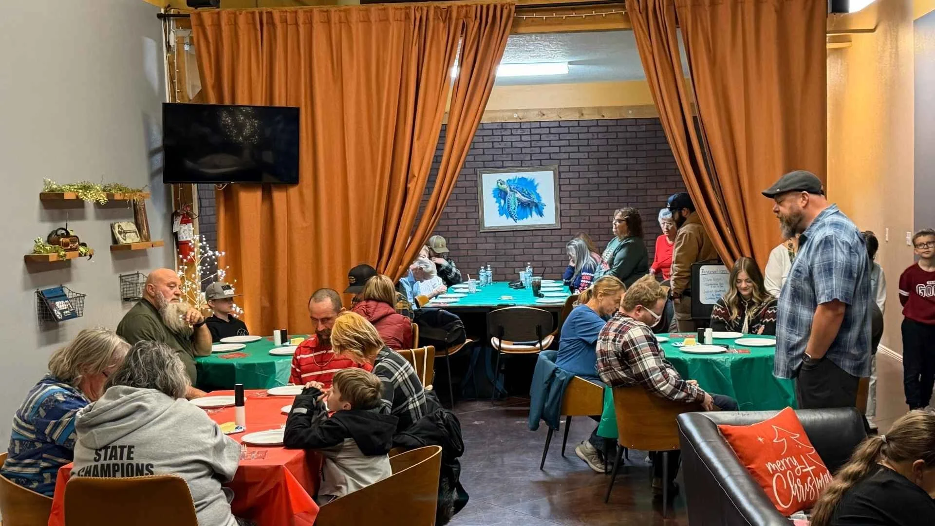 Pastor Ray Ewing and other people are enjoying a delicious meal at New Journey Church's Christmas Dinner event.