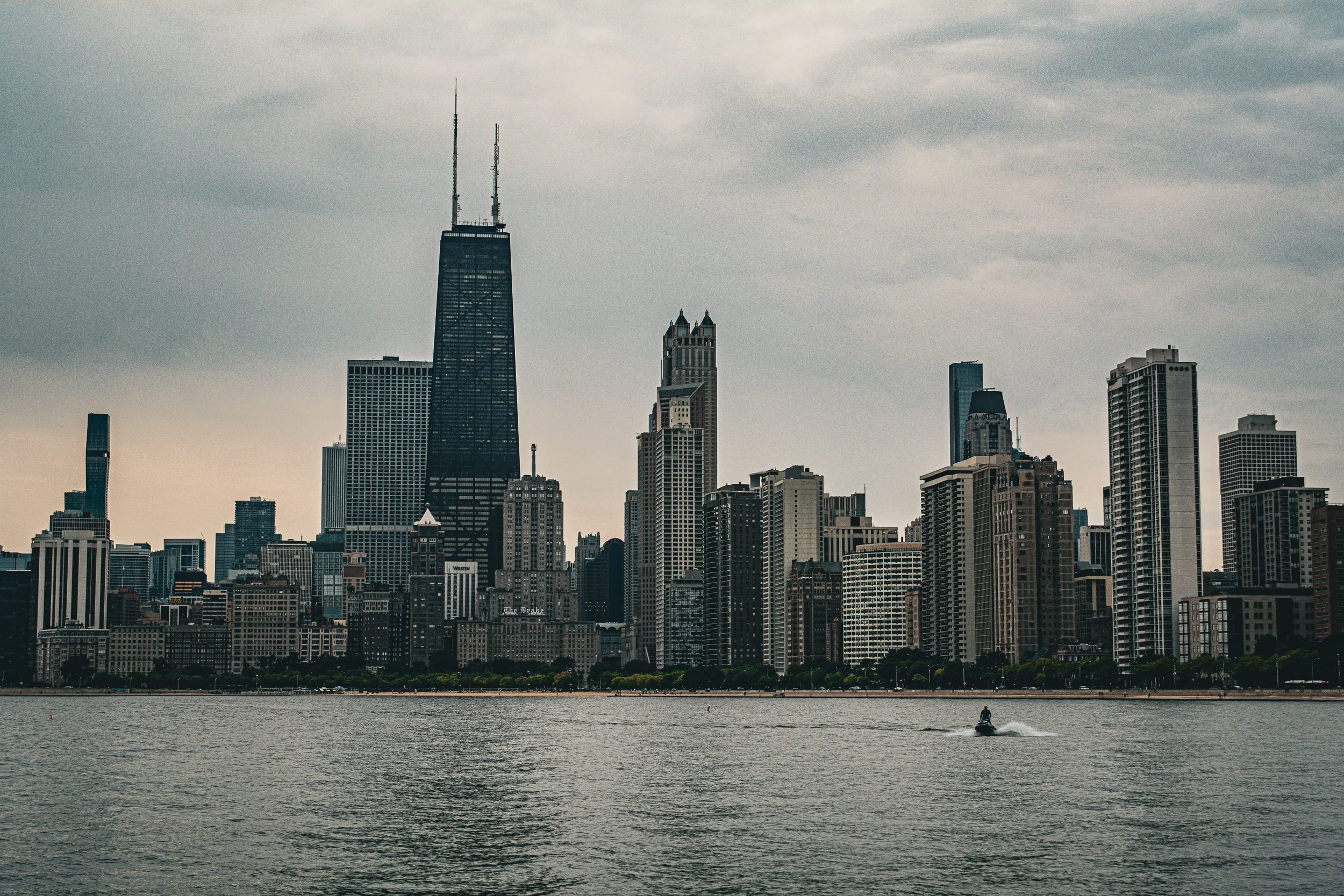 Lakeview Skyline - A sweeping, balanced vista of the waterfront skyline reflecting across the calm surface of the lake.