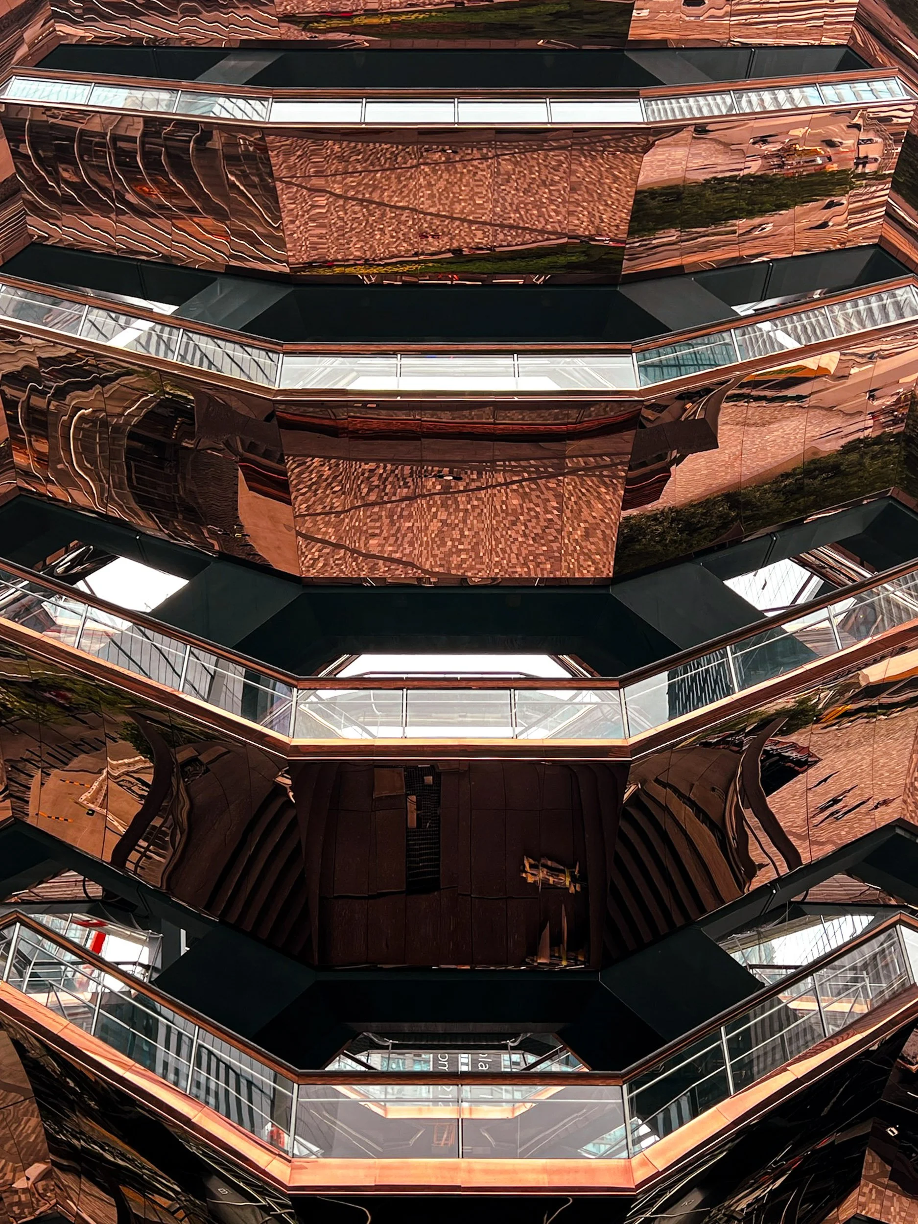 The Vessel Exterior Geometry - A wide, detailed exterior view focusing on the dramatic bronzed steel angles and monumental presence of The Vessel at Hudson Yards.