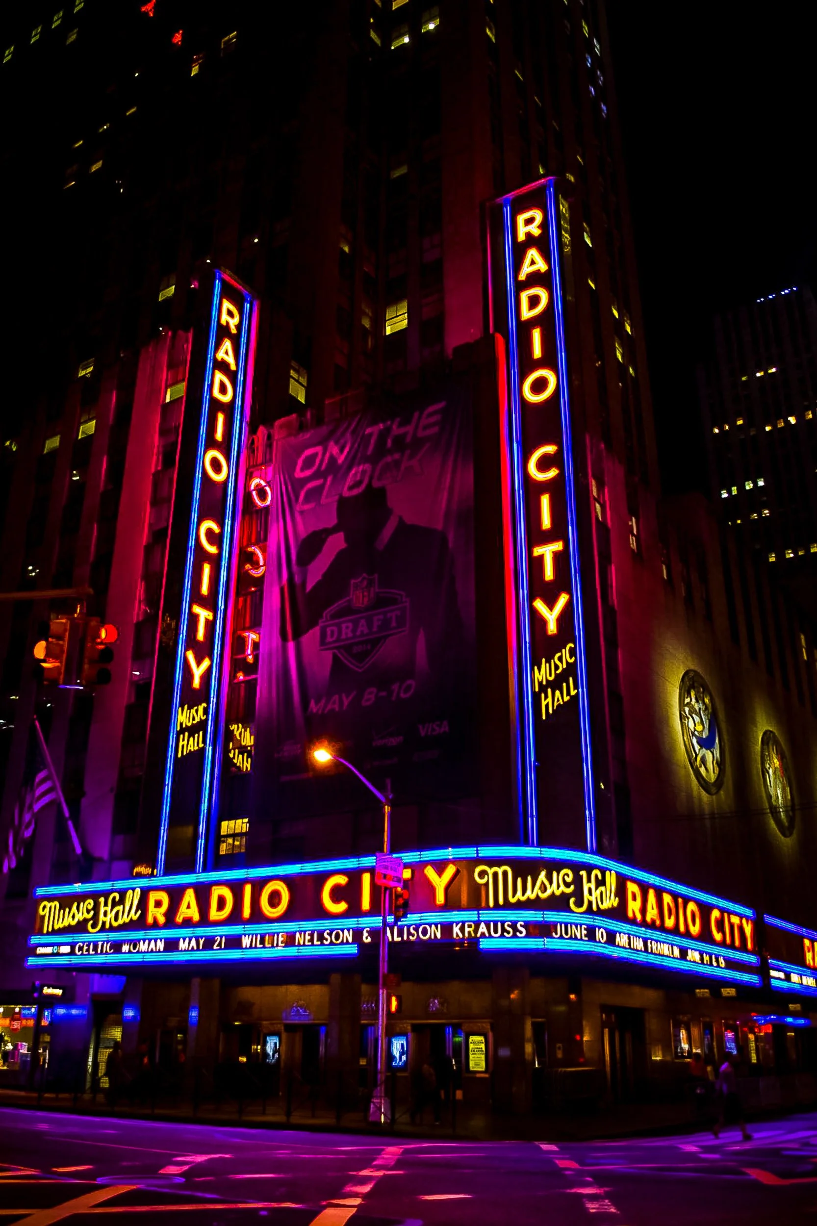 Radio City Music Hall Neon at Night - The brilliant, glowing red and yellow neon signage of Radio City Music Hall slashing vertically through the dark city night.