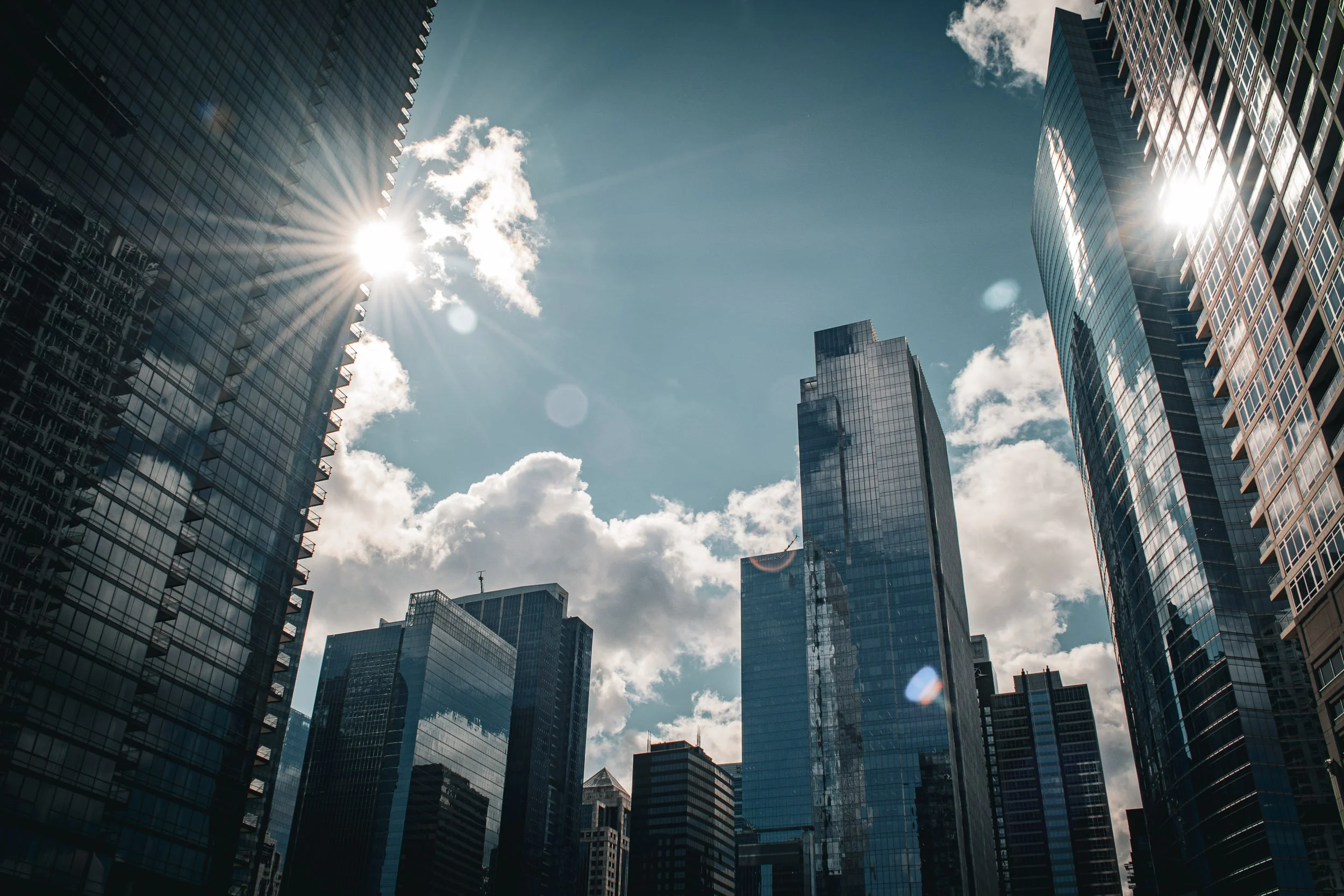 Sunburst and Skyscraper Canyon - A sunburst breaks through the dramatic canyon of high-rise buildings, casting sharp shadows and brilliant highlights along the urban grid.