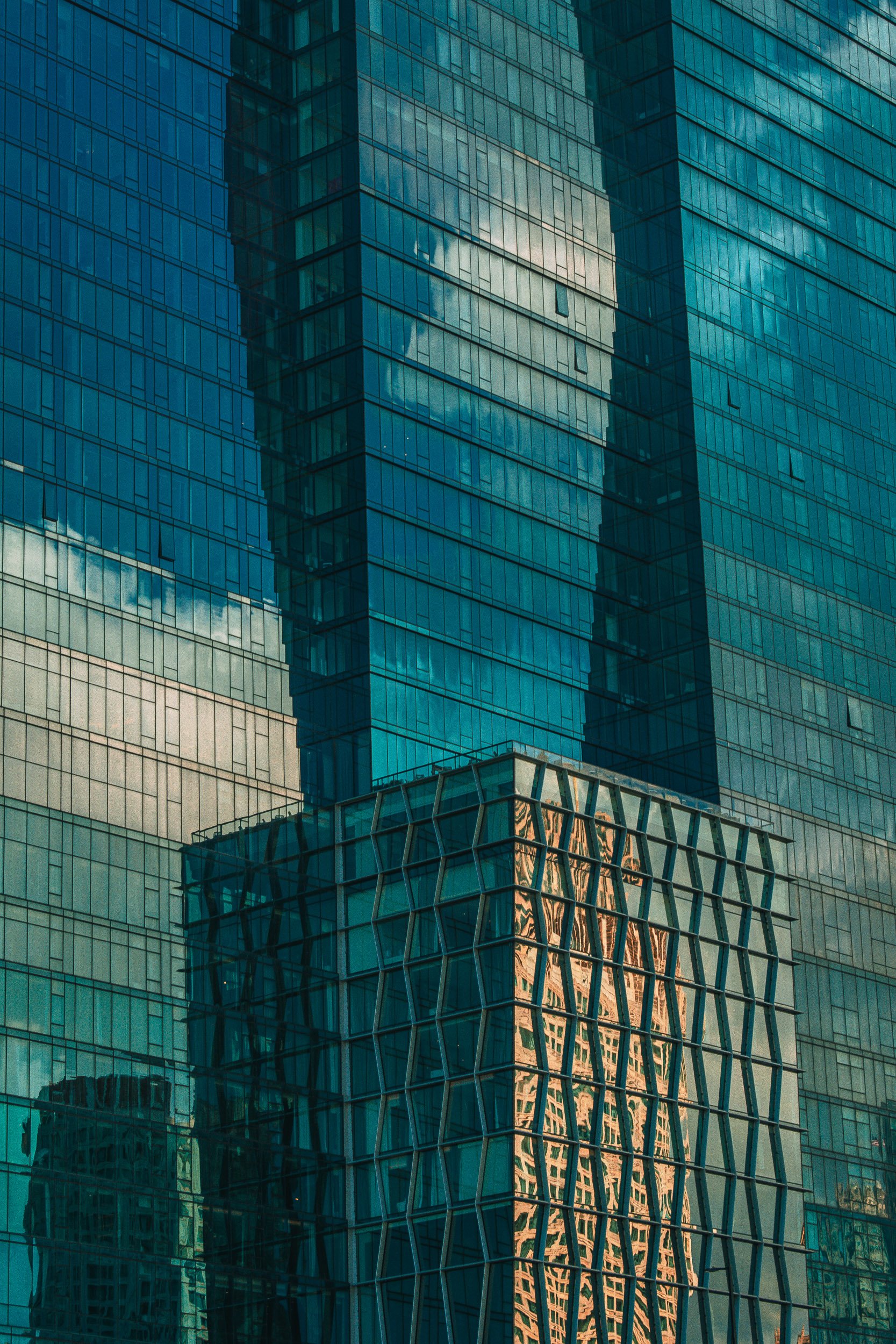 Compressed Glass Skyscraper Facades - A towering vertical gaze up at multiple glass-walled high-rises reflecting one another in a maze of structural geometry.