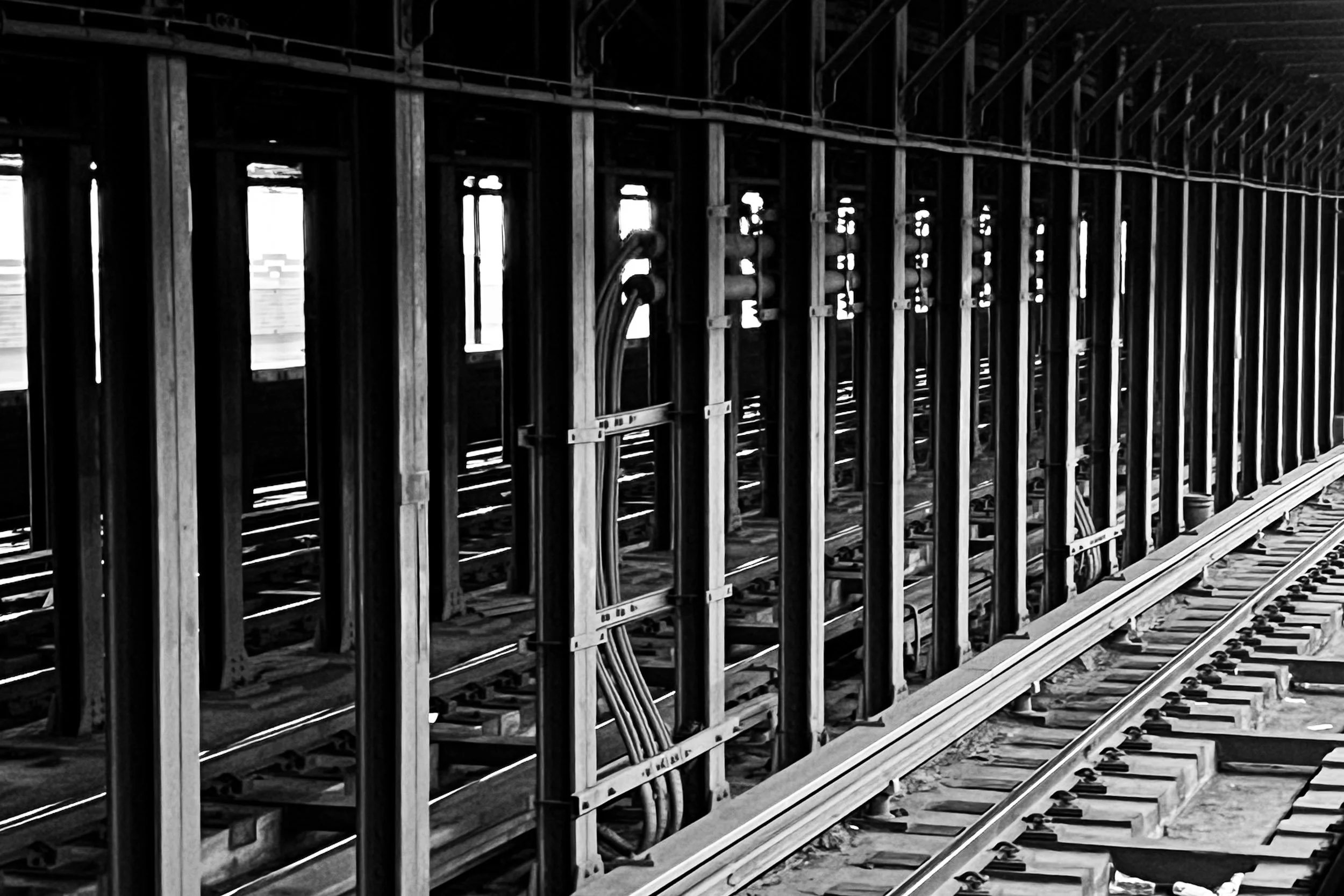 Underground Rhythm - A leading-line composition tracing the repeating fluorescent lights and tiled curves of an empty subway station tunnel.
