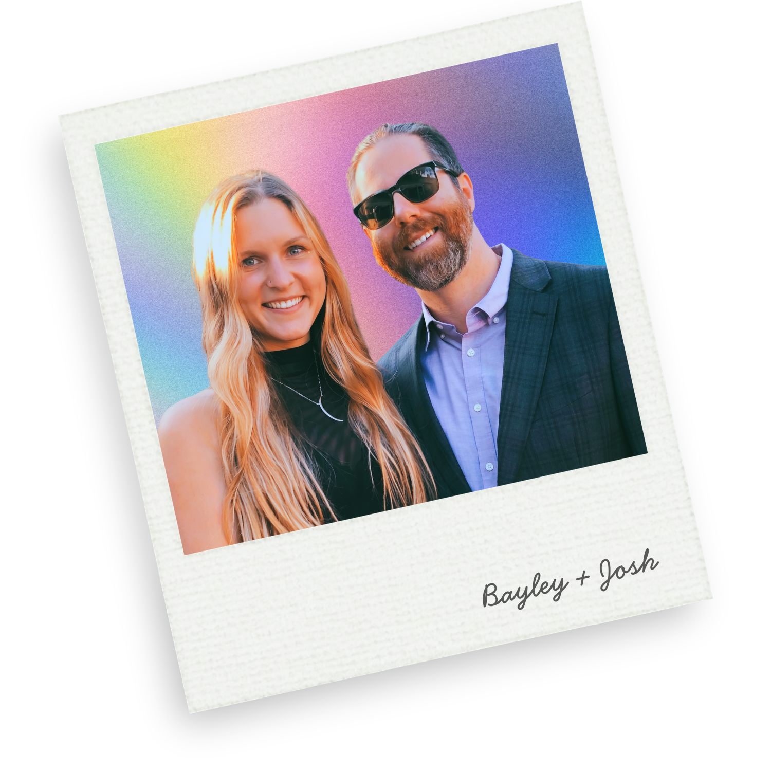 A smiling young woman with long blonde hair and a man with a beard, wearing sunglasses, standing together in front of a rainbow-colored background, with 'Bayley + Josh' written on a white border at the bottom of the photo.