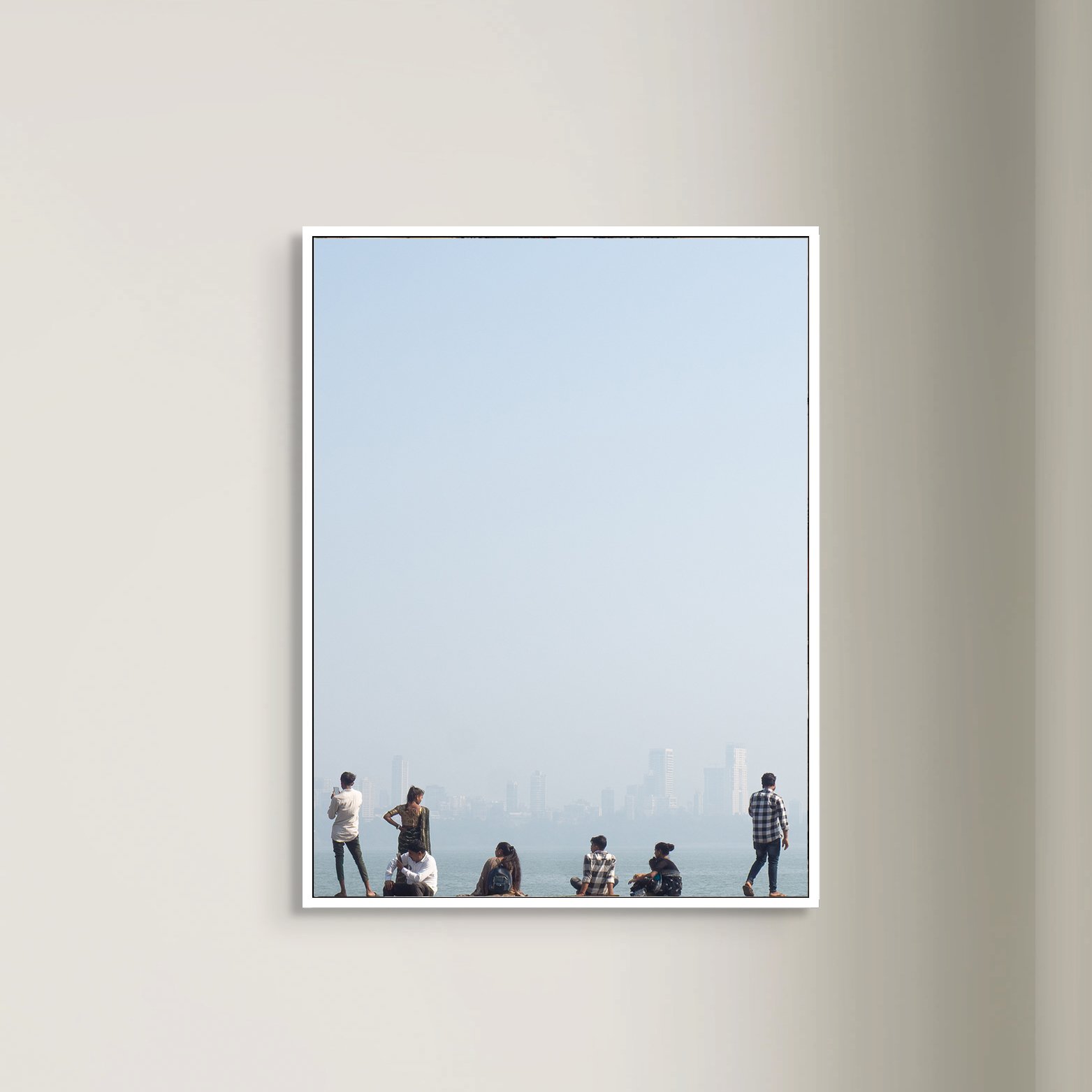 Photo of a large window showing a city skyline and several people standing or sitting in front of the window.