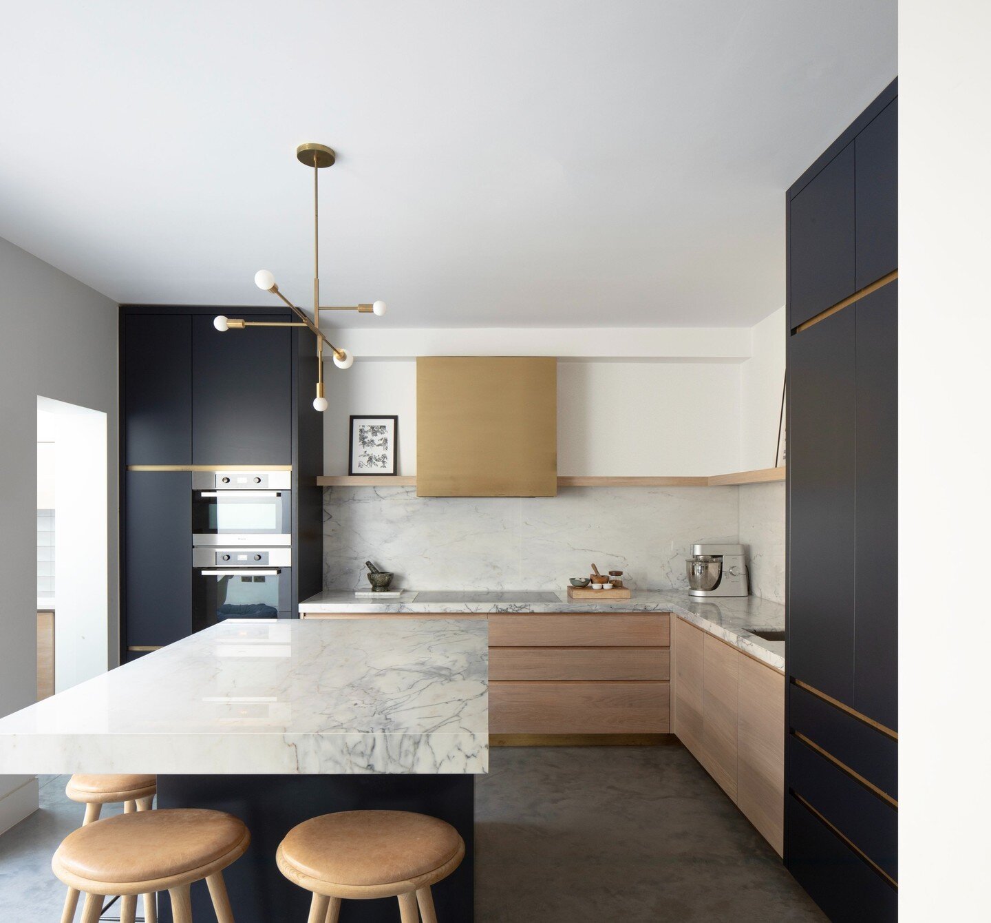 The kitchen at our Herne Hill project is both contemporary and luxurious. Mixing warm brass tones and dark navy with a polished concrete floor and feature marble worktops creates a refined yet inviting interior- a family kitchen perfect for both host