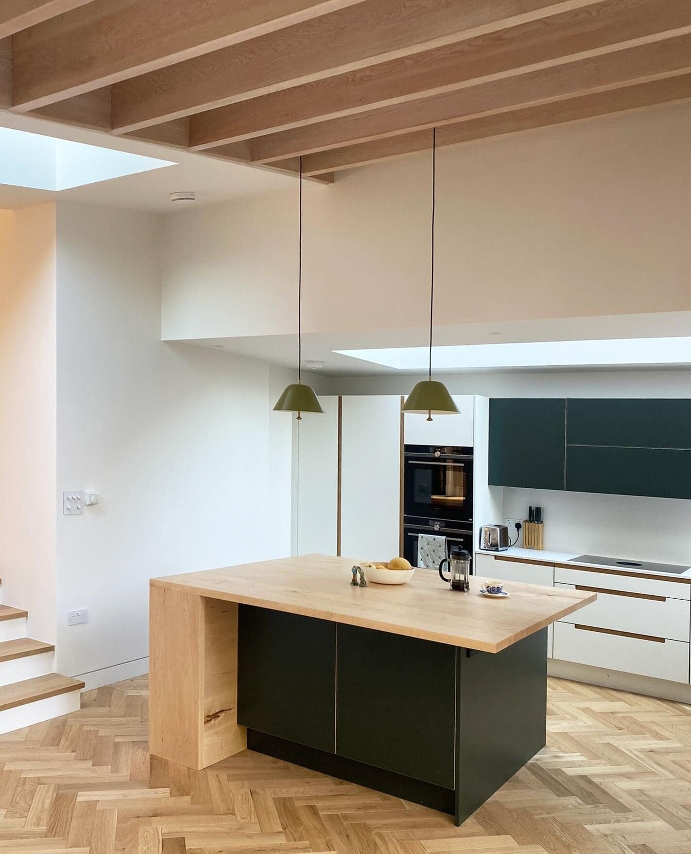 A feature up and over window in our recently completed residential project in Brockley, brings natural daylight into the heart of the kitchen space, with a full length strip roof light positioned in the sloping green roof which defines the social spa