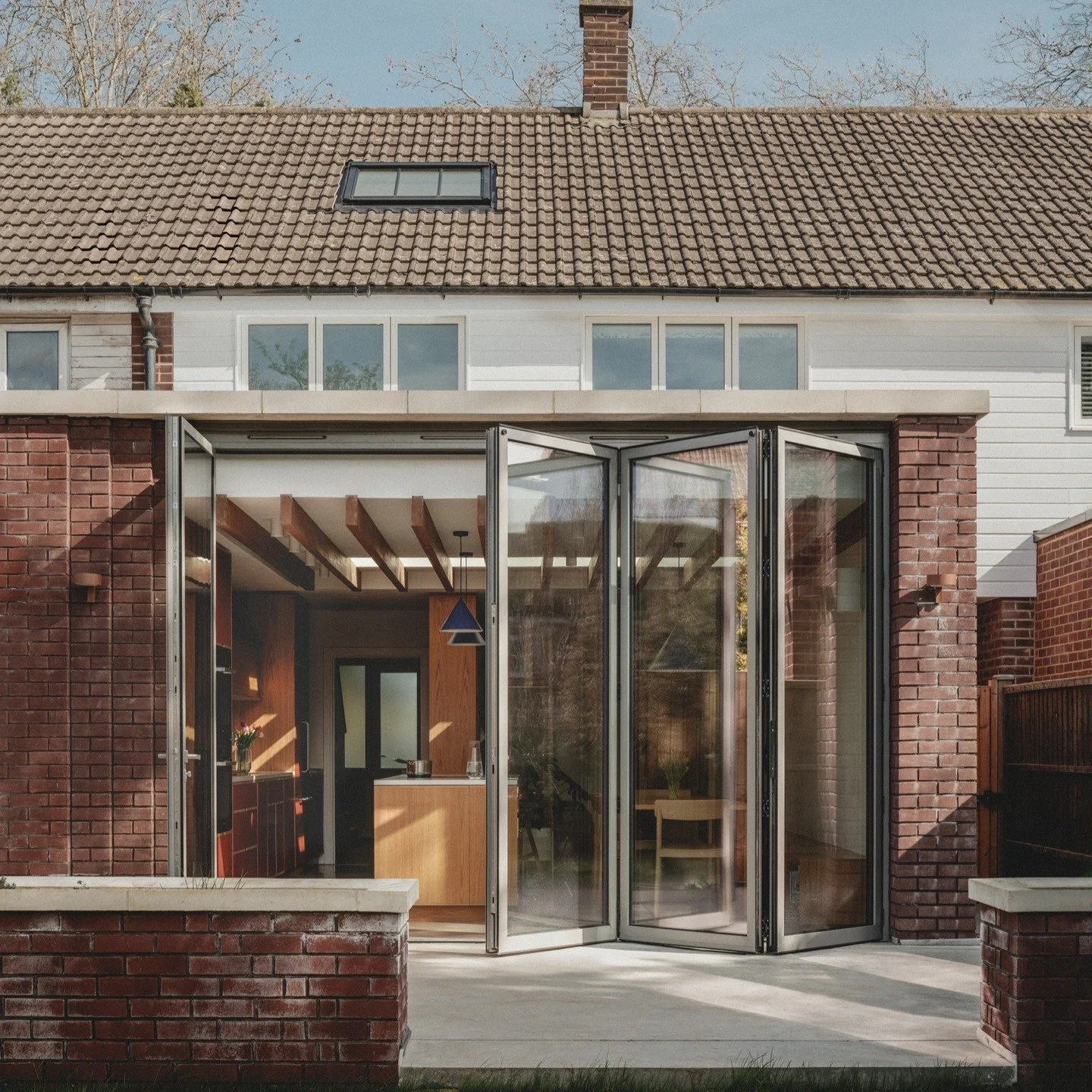 2/3 - At ground floor a modest extension to the rear of our Dulwich House creates additional floor space to facilitate the large open plan kitchen, dining and living area. Full width bi-folding doors greatly enhance the connection with the rear garde
